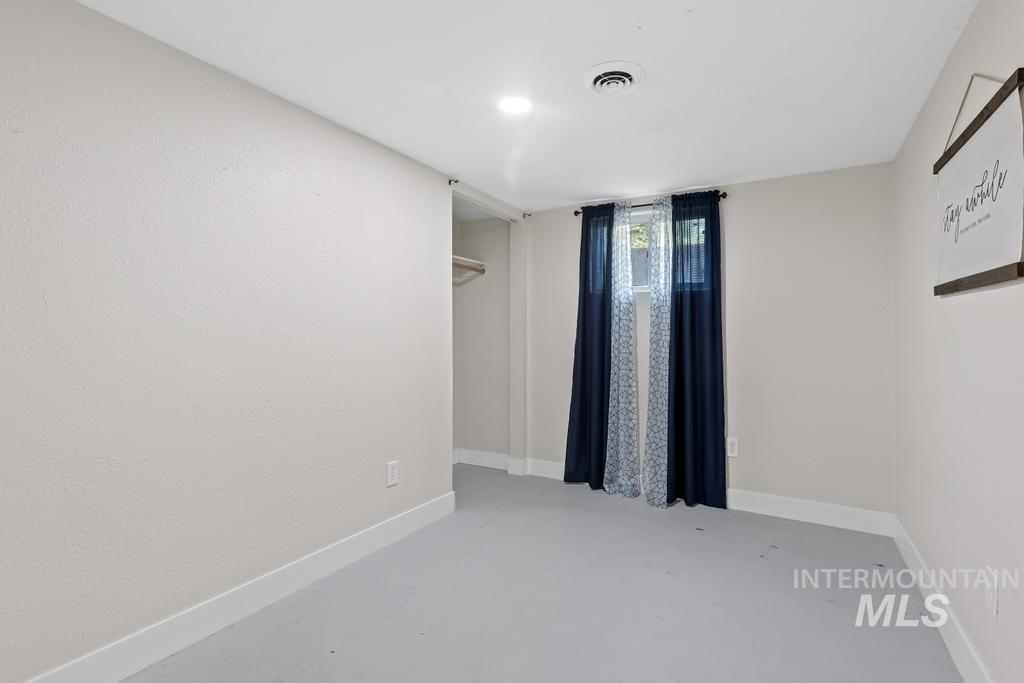 Empty room featuring baseboards and finished concrete floors