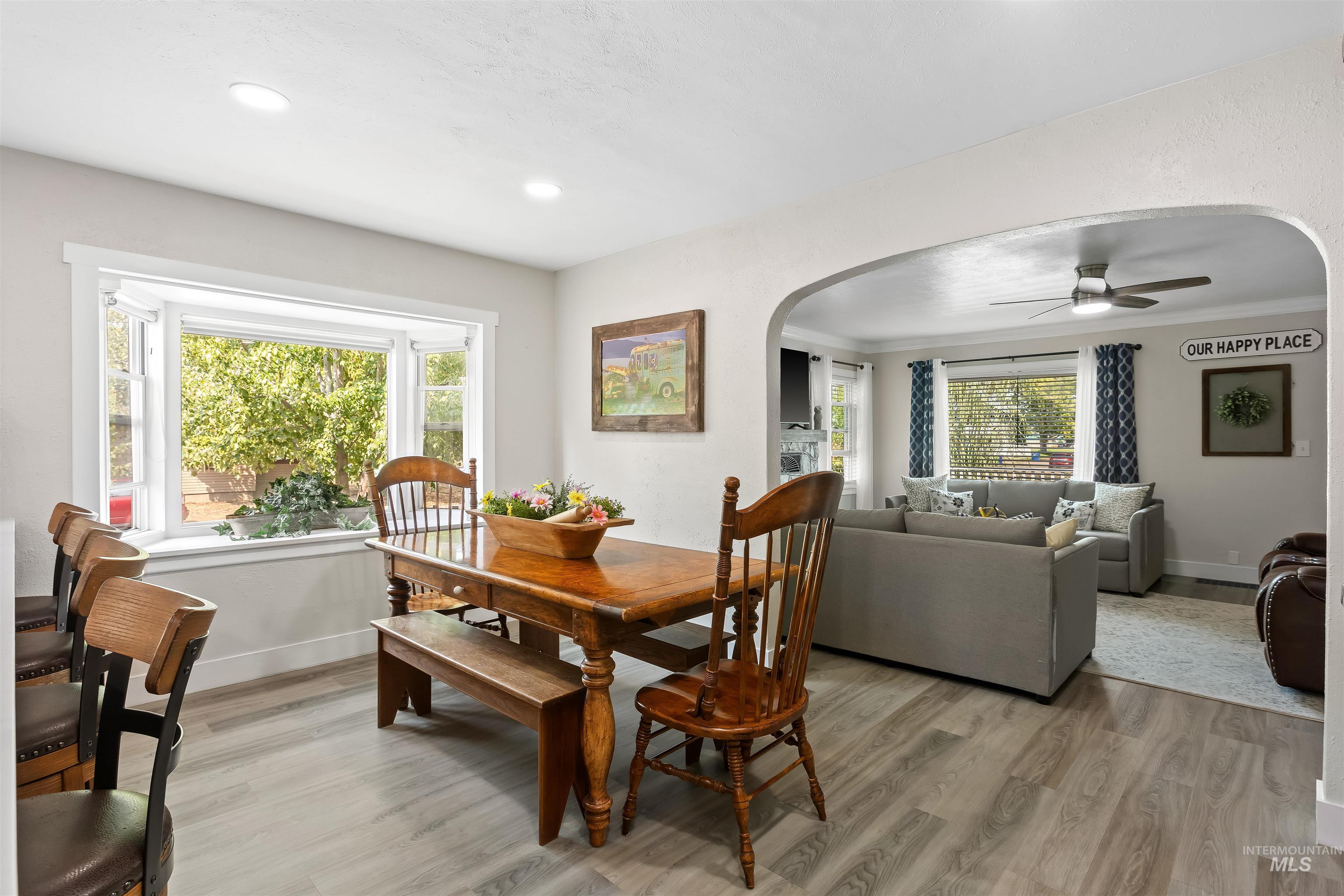 Dining room featuring light wood-style floors, arched walkways, a ceiling fan, and recessed lighting
