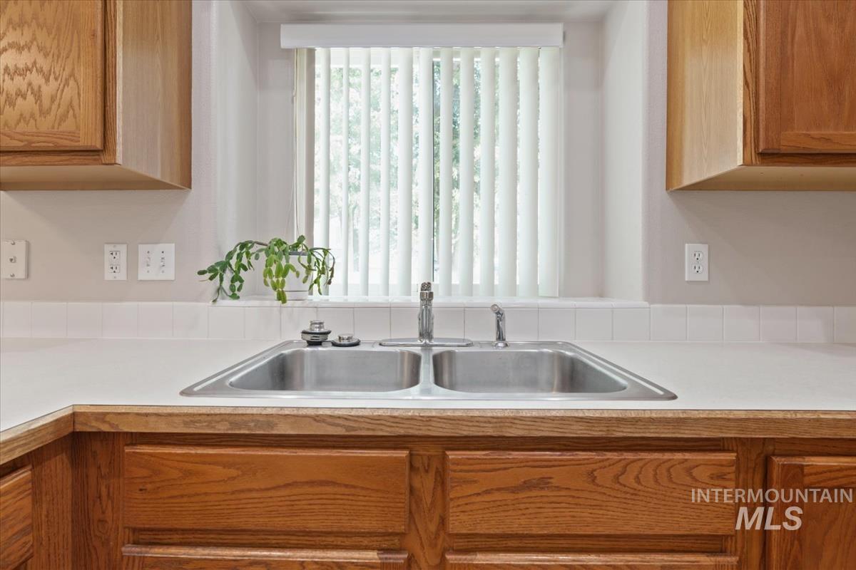 Kitchen with light countertops, plenty of natural light, and brown cabinets