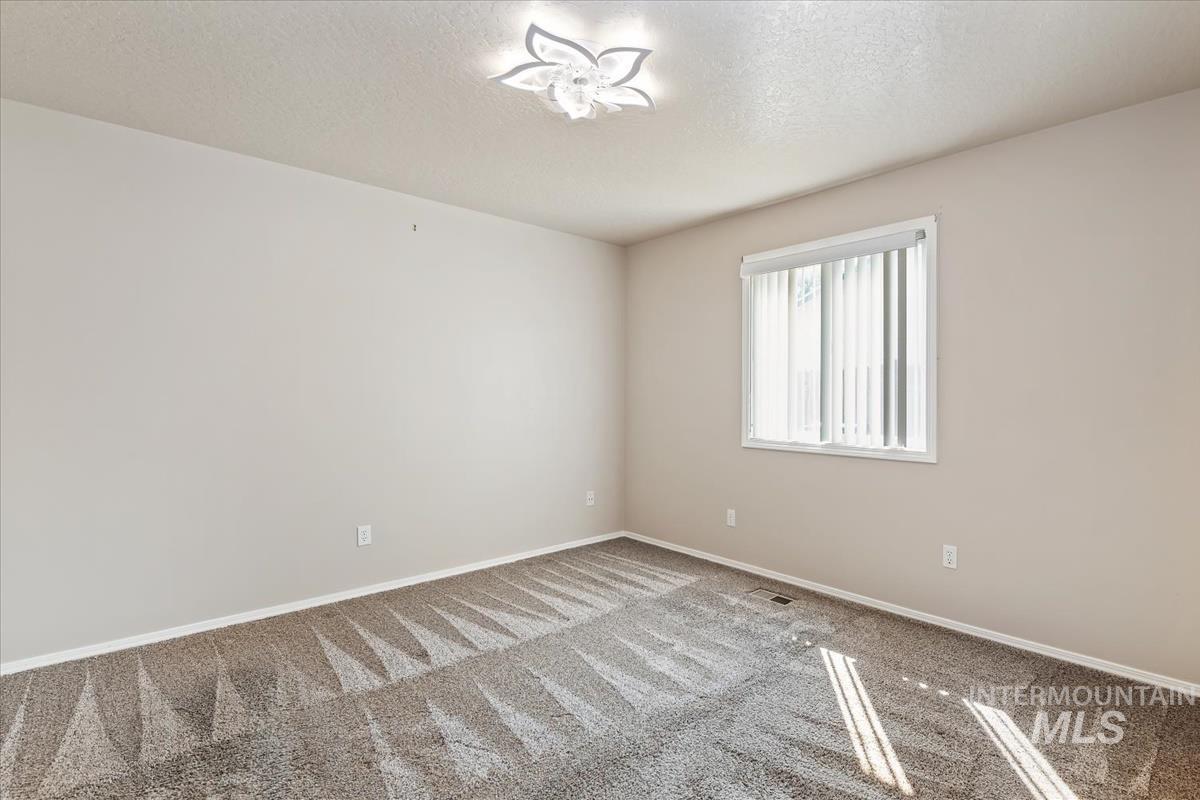 Spare room with a textured ceiling and carpet flooring
