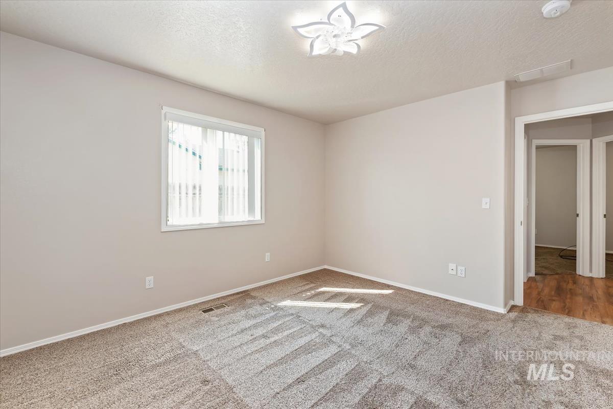 Carpeted empty room featuring a textured ceiling