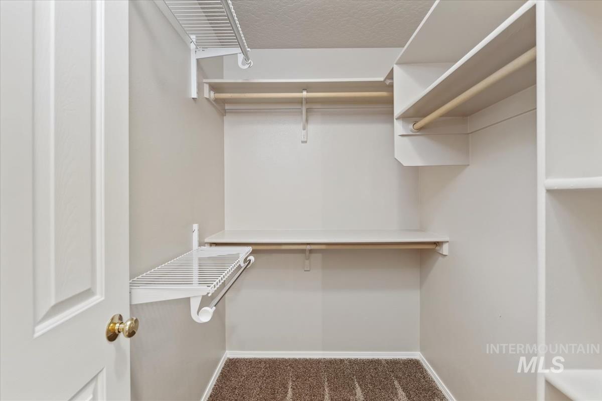 Spacious closet with dark carpet