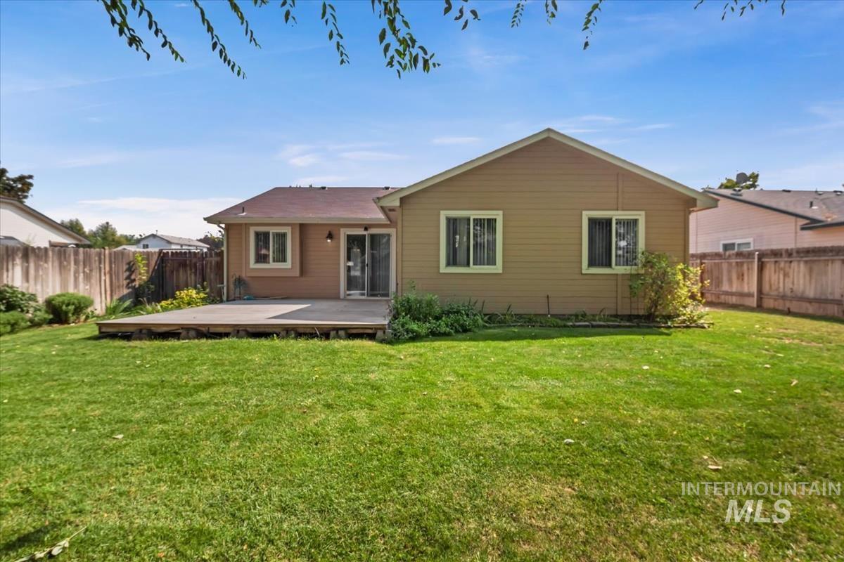 Back of property with a fenced backyard and a wooden deck