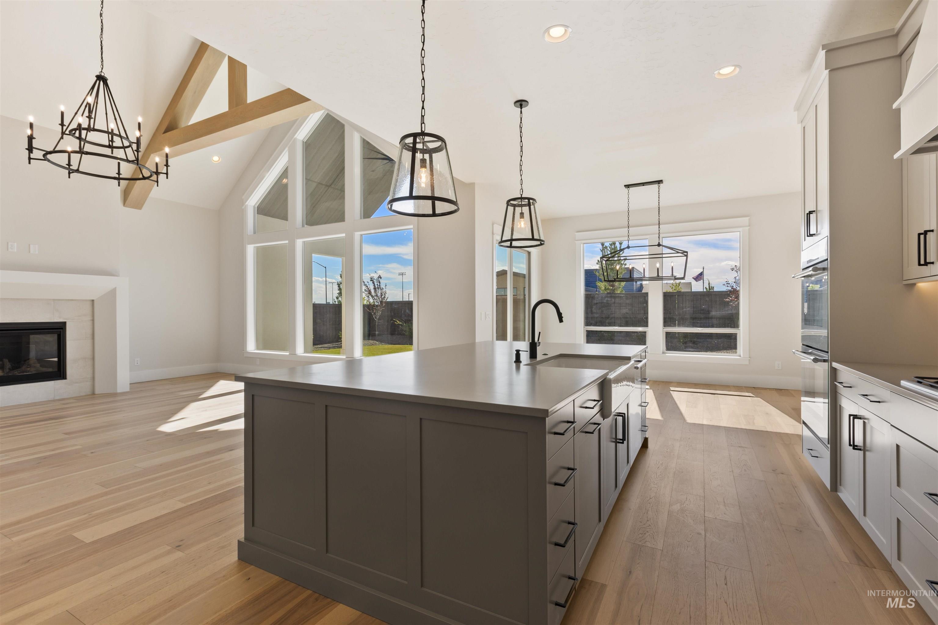 Kitchen featuring a chandelier, light wood-style flooring, an island with sink, open floor plan, and recessed lighting