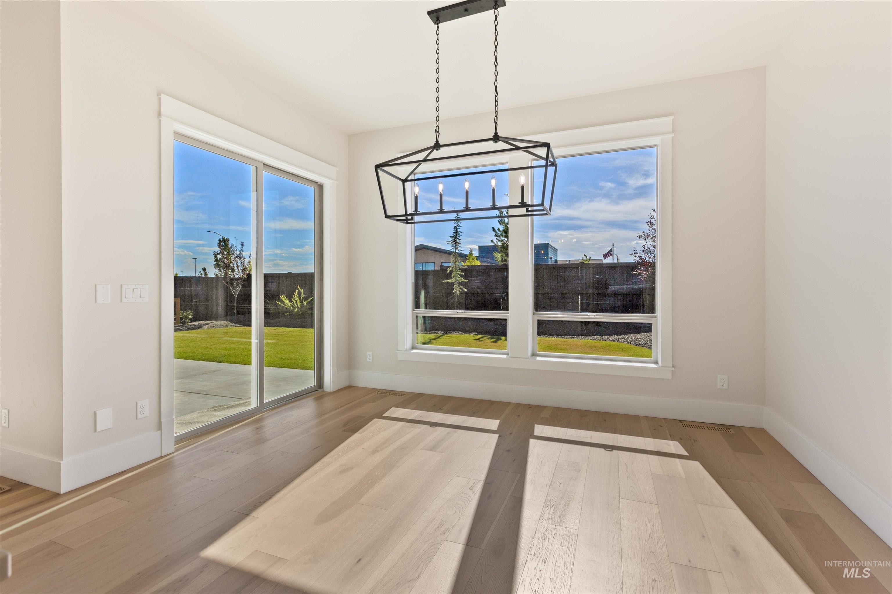 Unfurnished dining area featuring a chandelier and wood finished floors