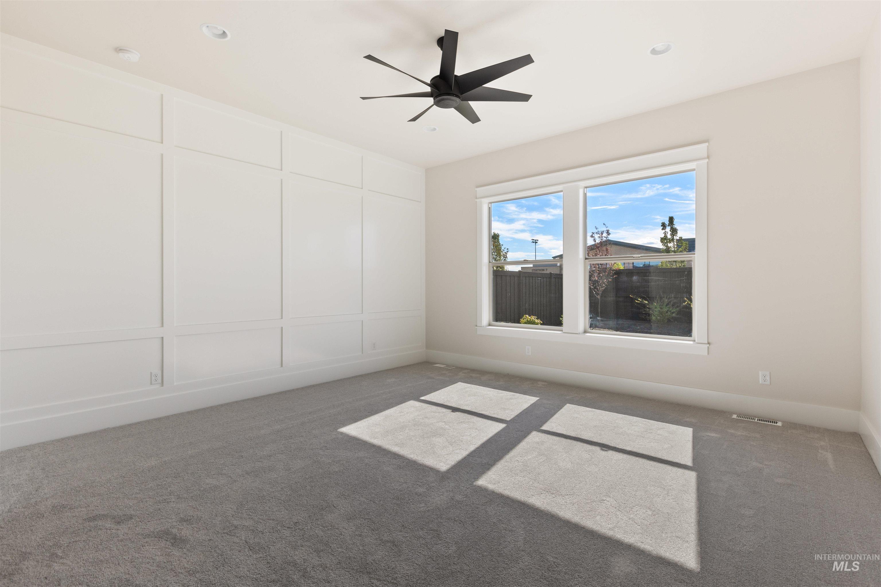 Empty room with carpet floors and a ceiling fan