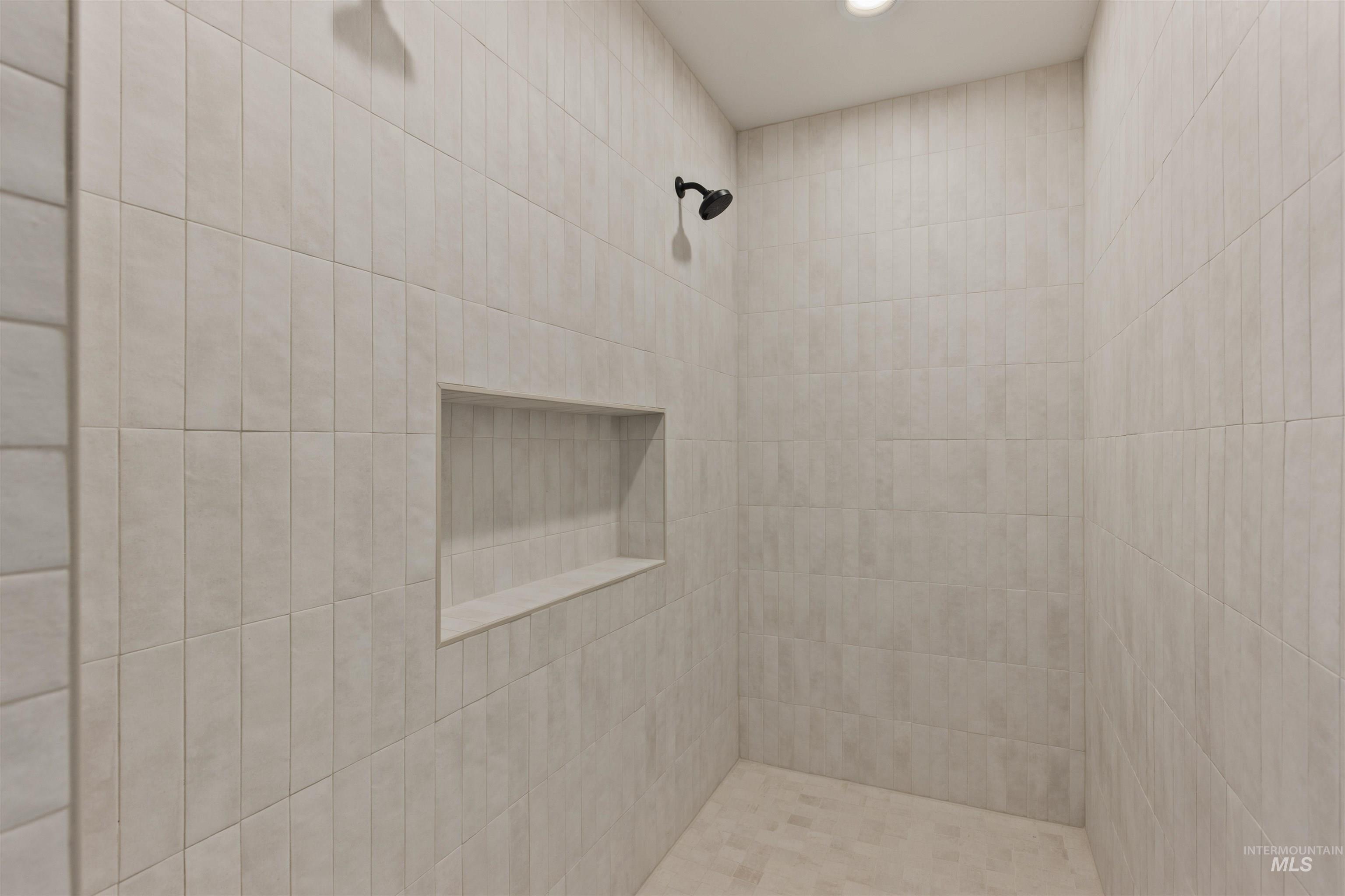 Full bath with tiled shower and recessed lighting
