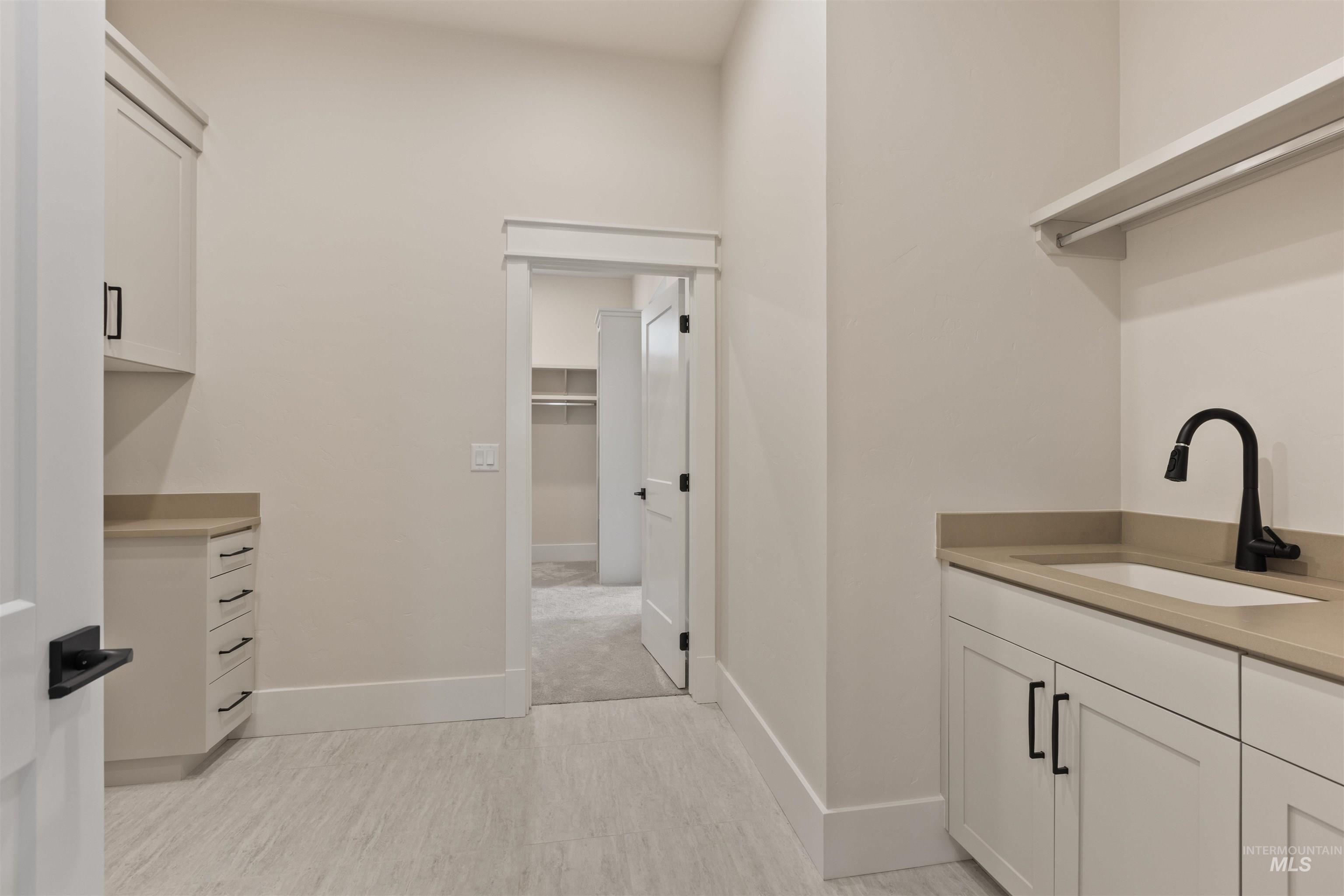 Laundry room featuring a sink and baseboards