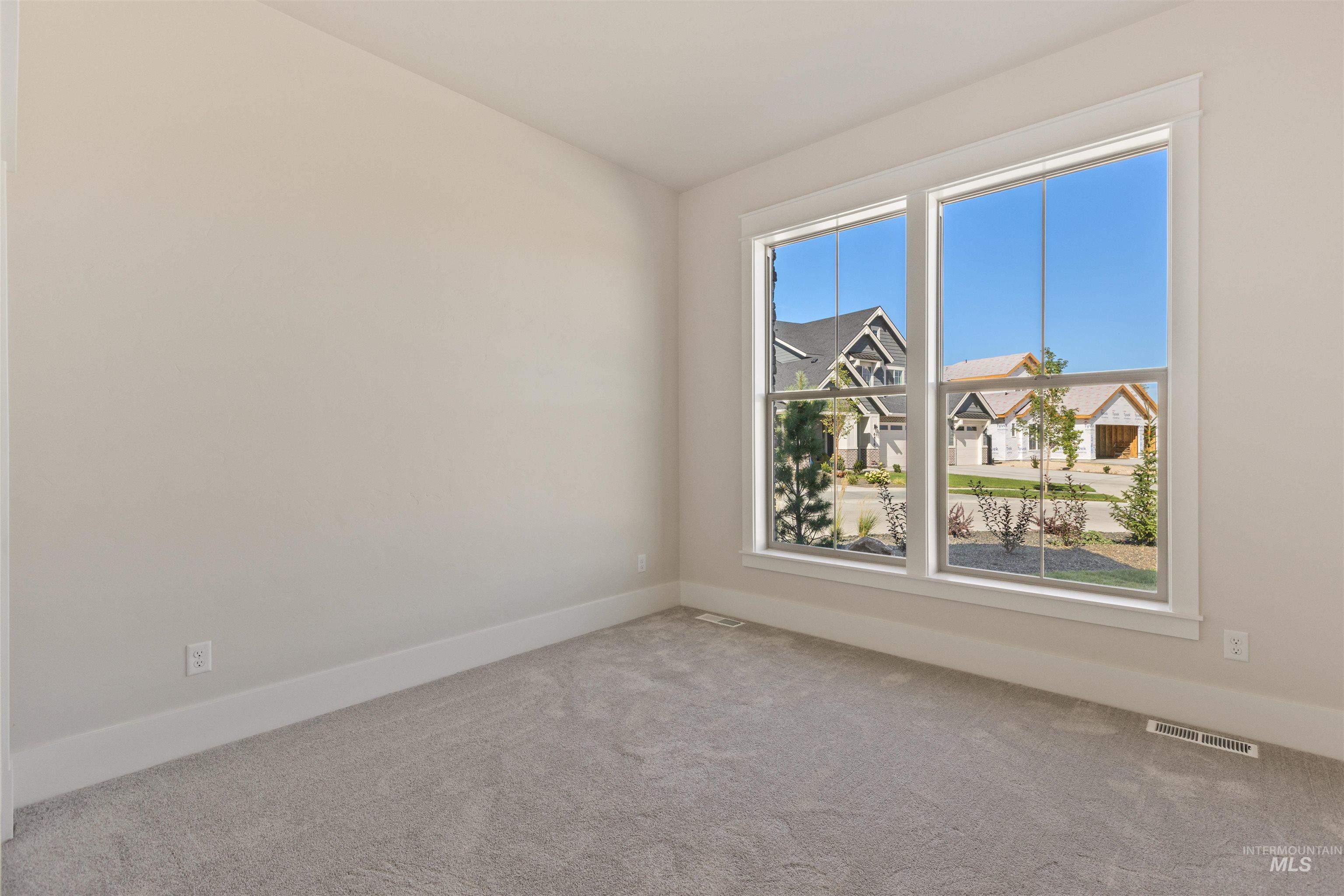 Carpeted spare room with baseboards