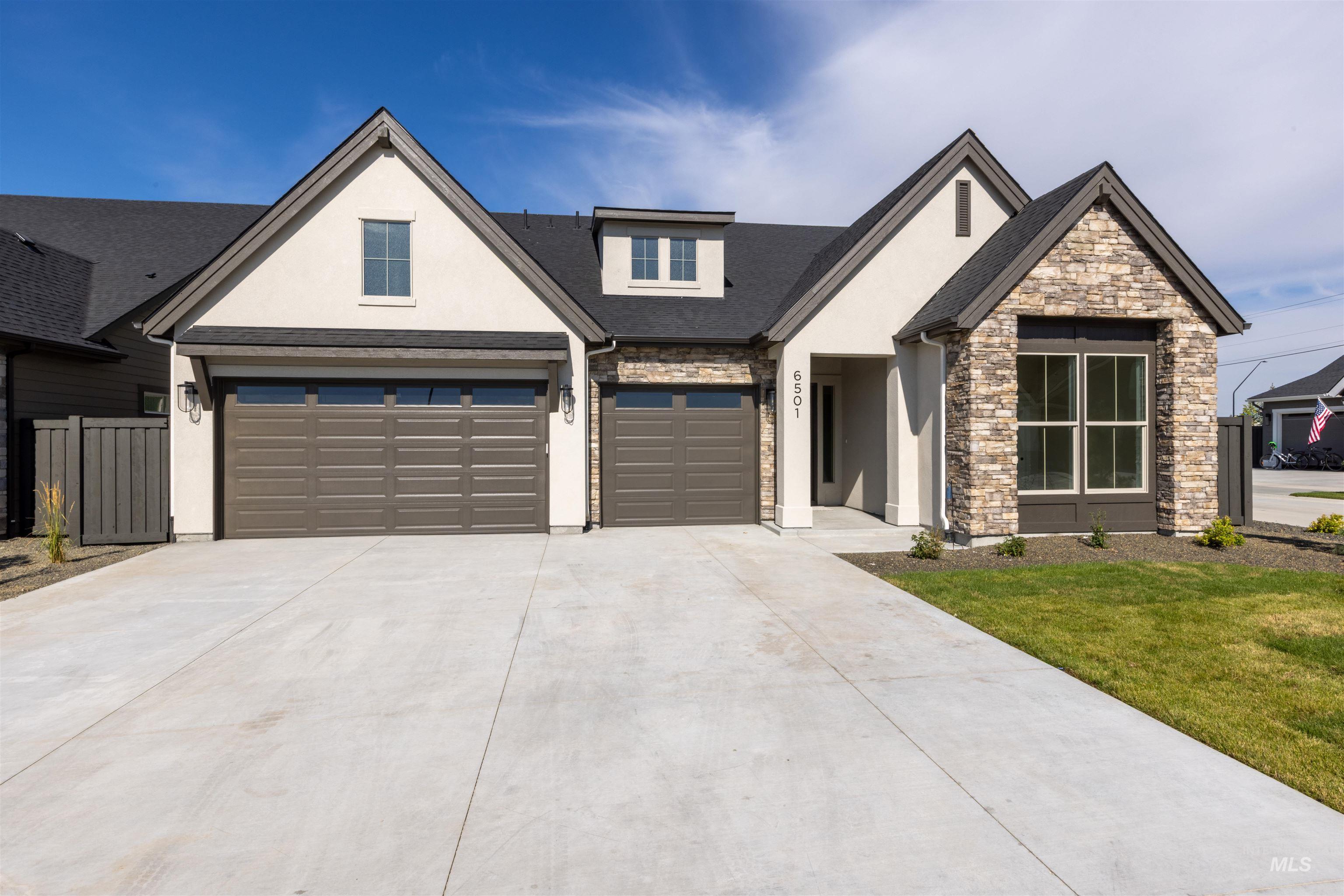 View of front facade featuring stucco siding, concrete driveway, an attached garage, stone siding, and a front lawn