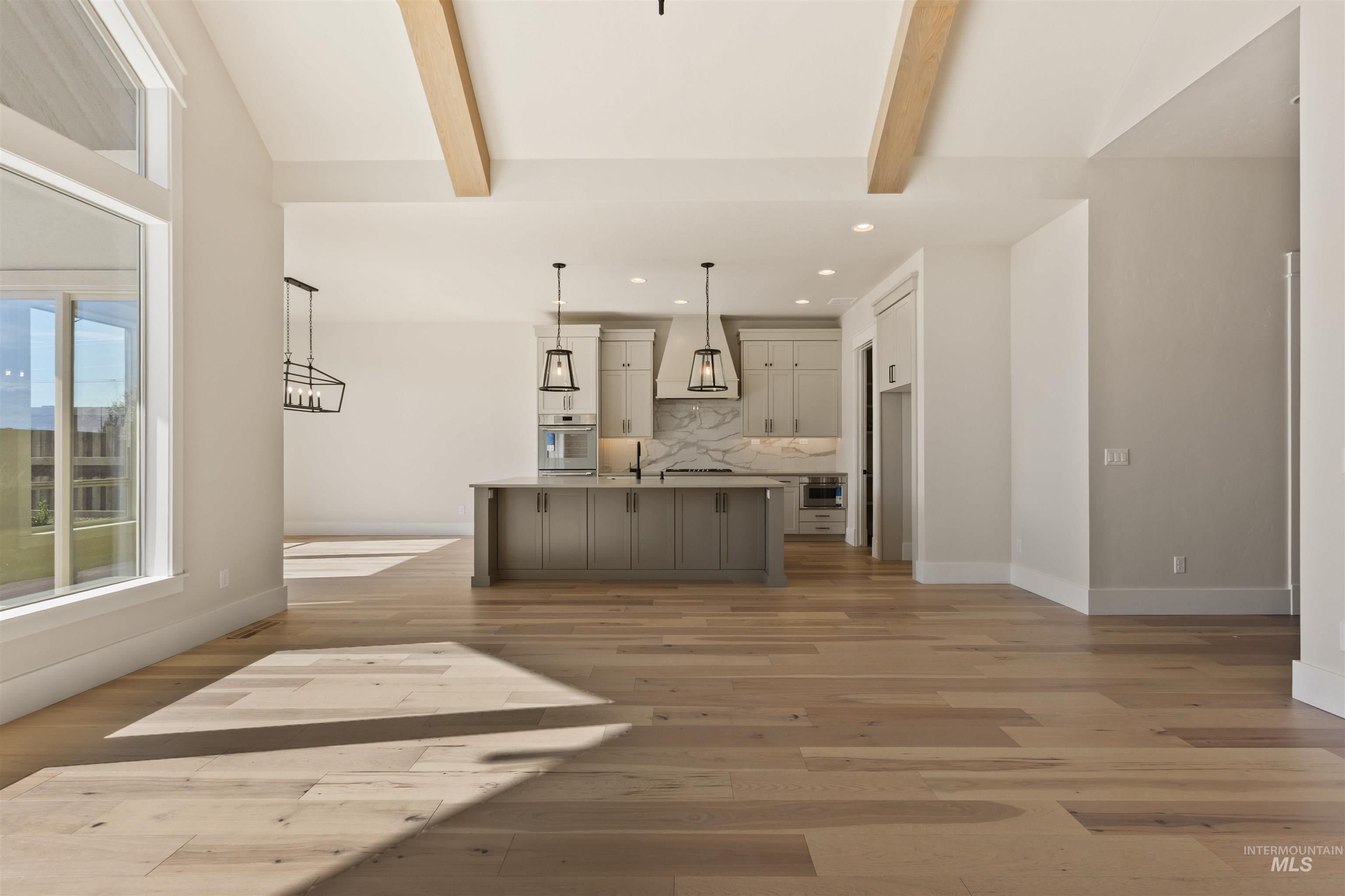 Kitchen featuring recessed lighting, backsplash, light wood finished floors, oven, and a center island with sink