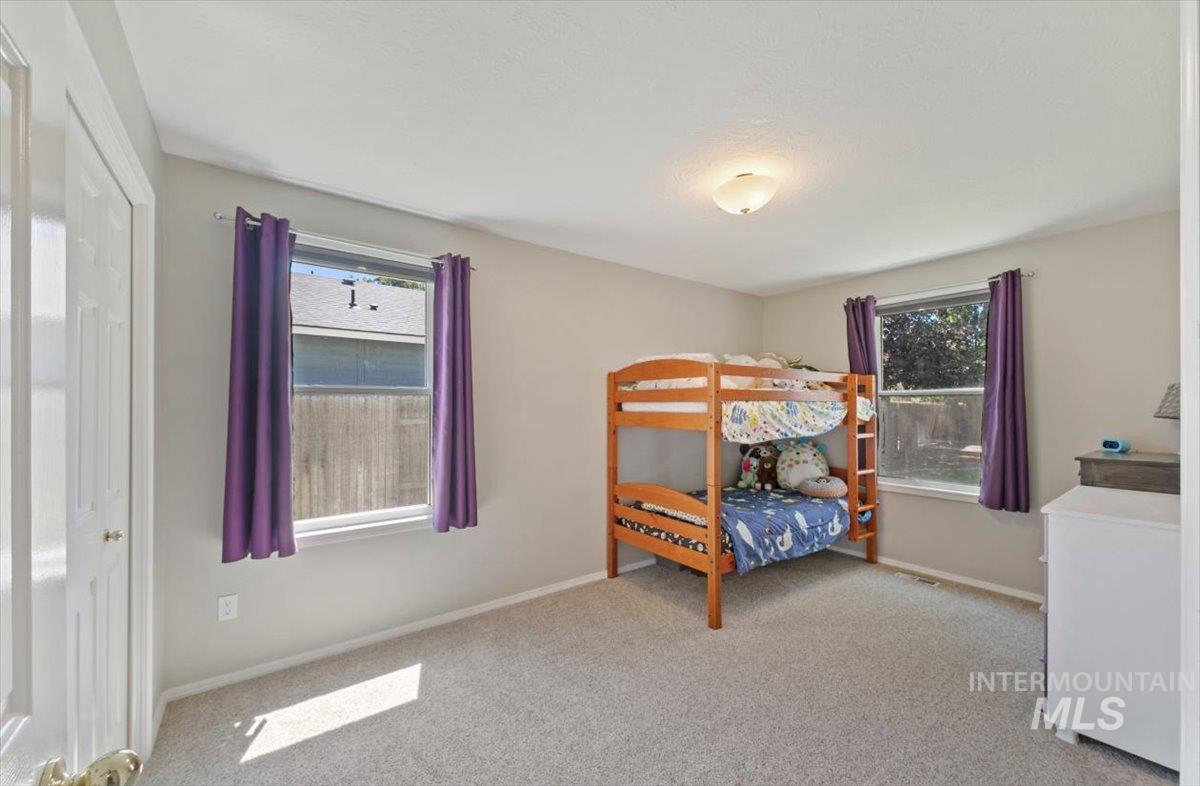 Bedroom featuring light colored carpet and baseboards