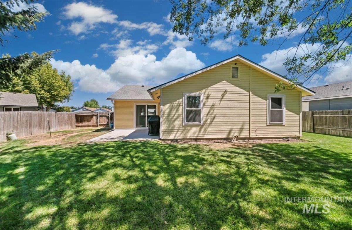 Rear view of house featuring a patio and a fenced backyard