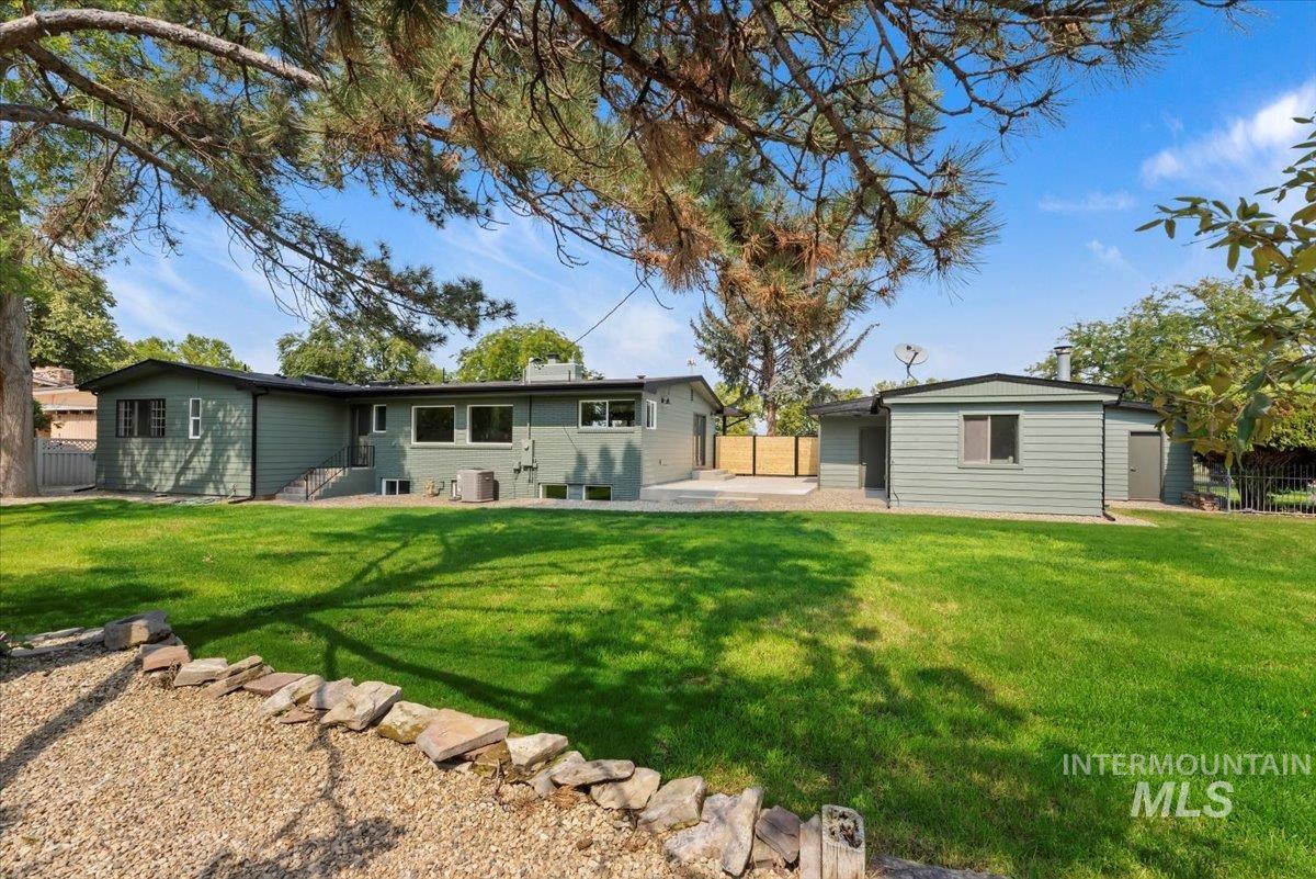 Rear view of house featuring a patio, a fenced backyard, and a chimney