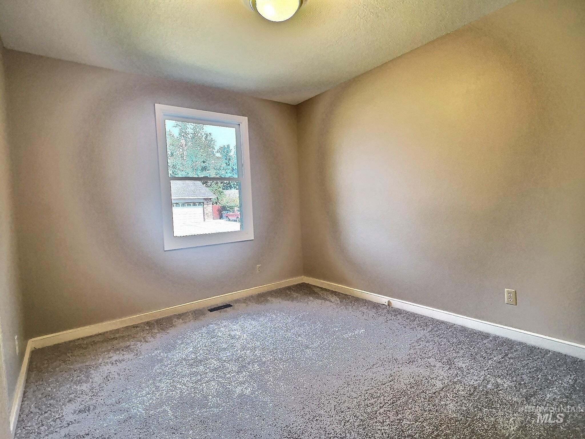 Spare room featuring carpet floors and a textured ceiling