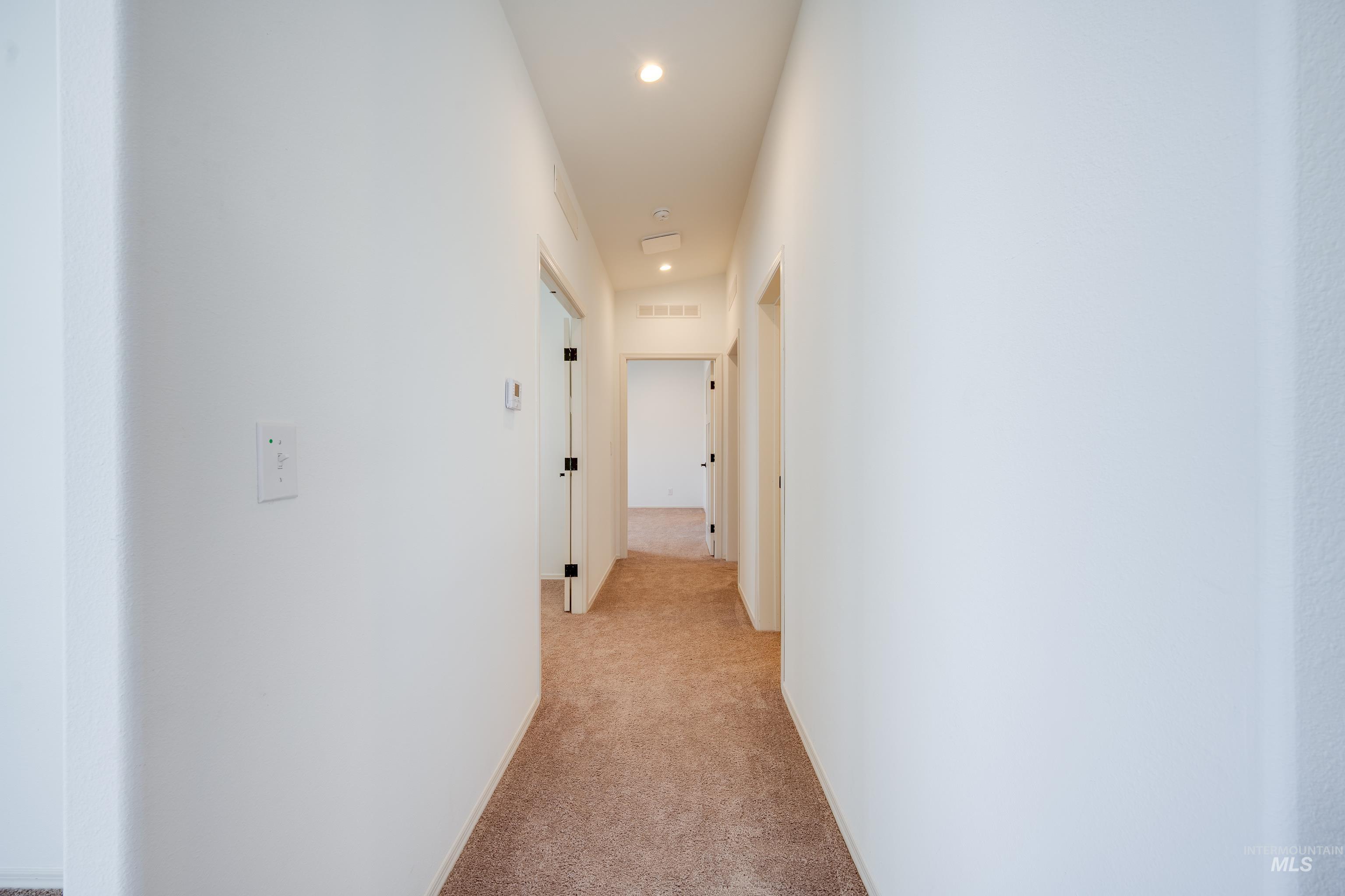 Hall featuring light colored carpet and recessed lighting
