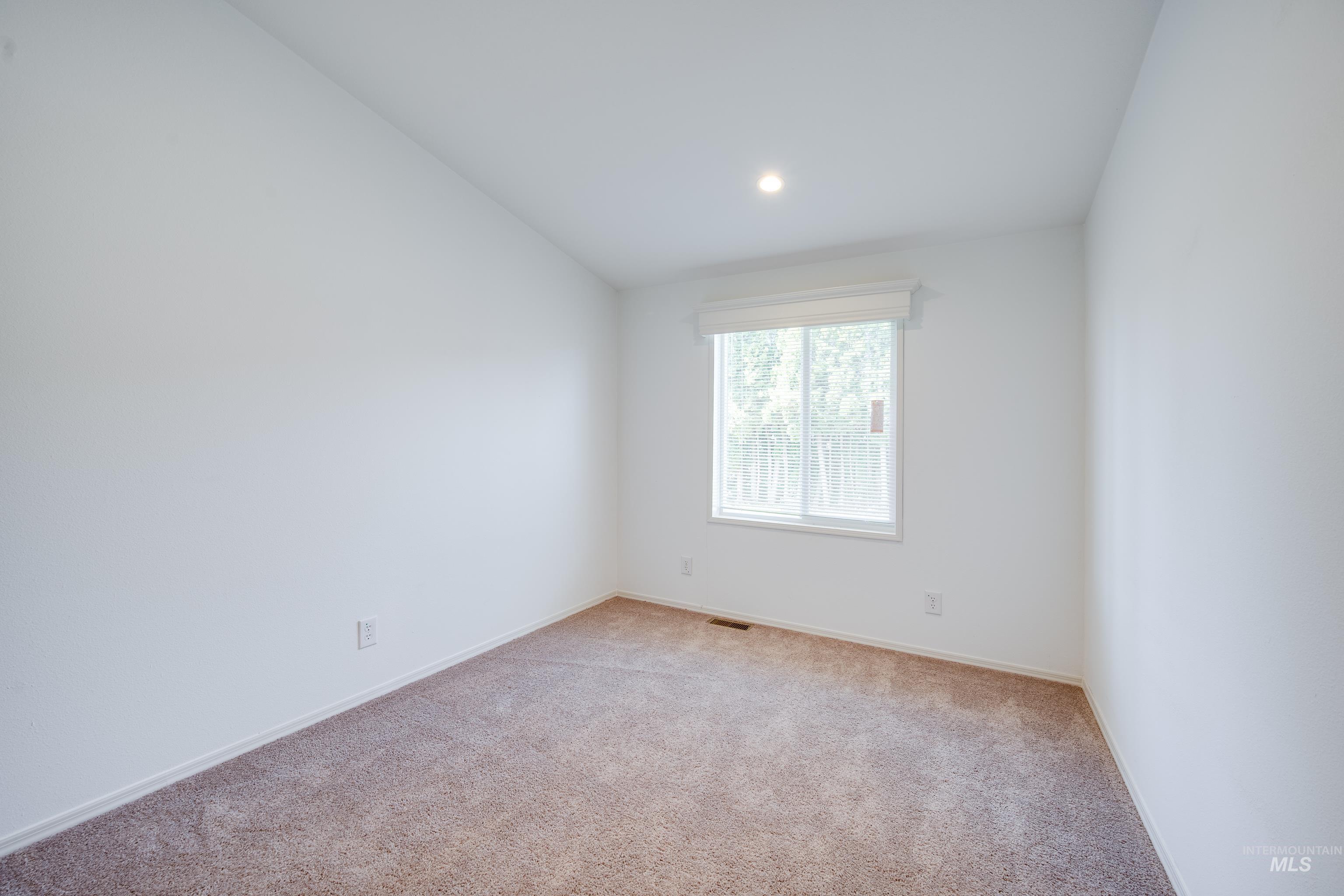 Empty room with light carpet, lofted ceiling, and recessed lighting
