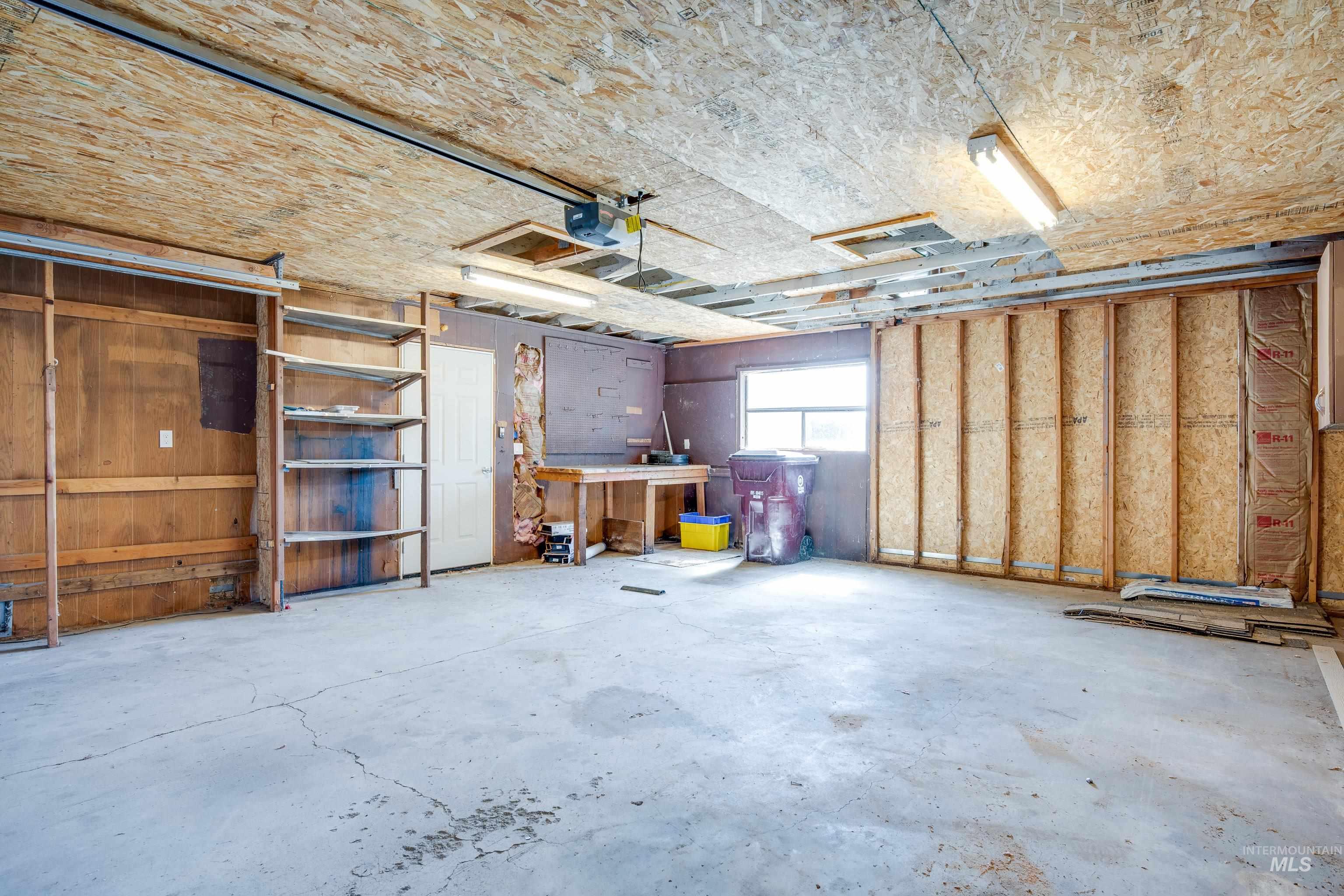 Garage featuring a garage door opener and a workshop area