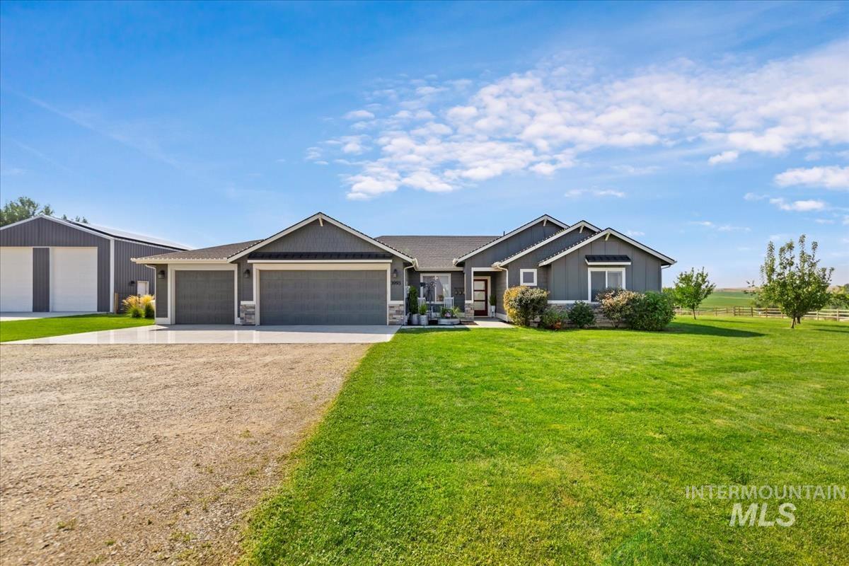 Craftsman inspired home with driveway, a front lawn, an attached garage, and stone siding
