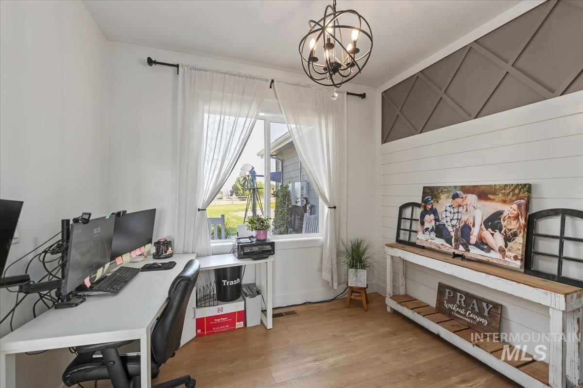 Office area featuring wood finished floors and a chandelier