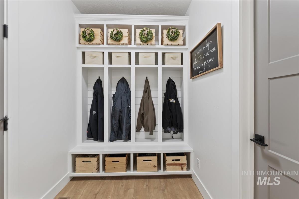 Mudroom featuring light wood-style flooring and baseboards