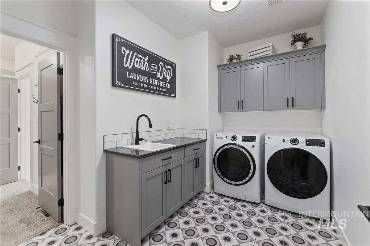 Laundry area featuring separate washer and dryer and cabinet space