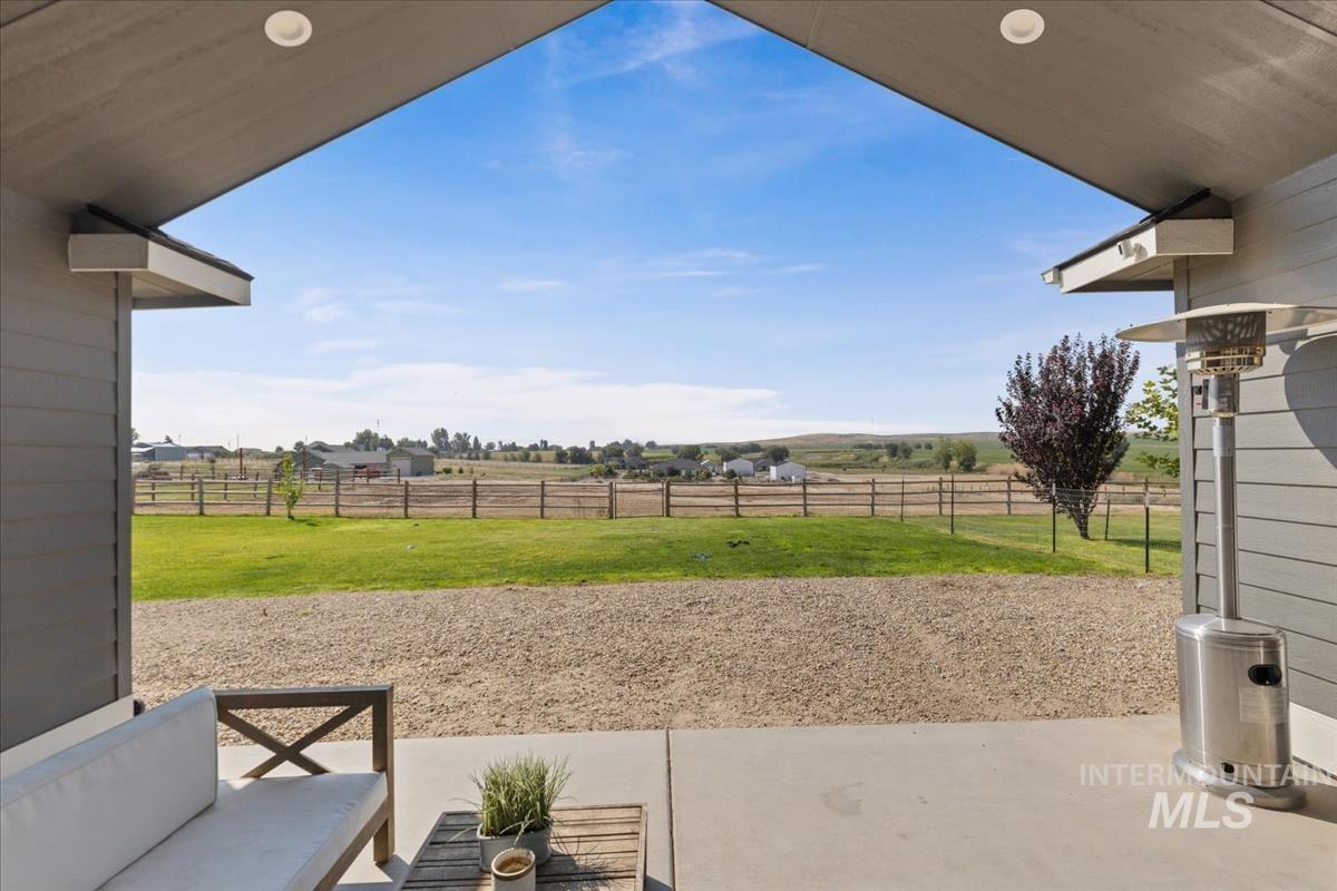 Fenced backyard with a patio area and a view of rural / pastoral area
