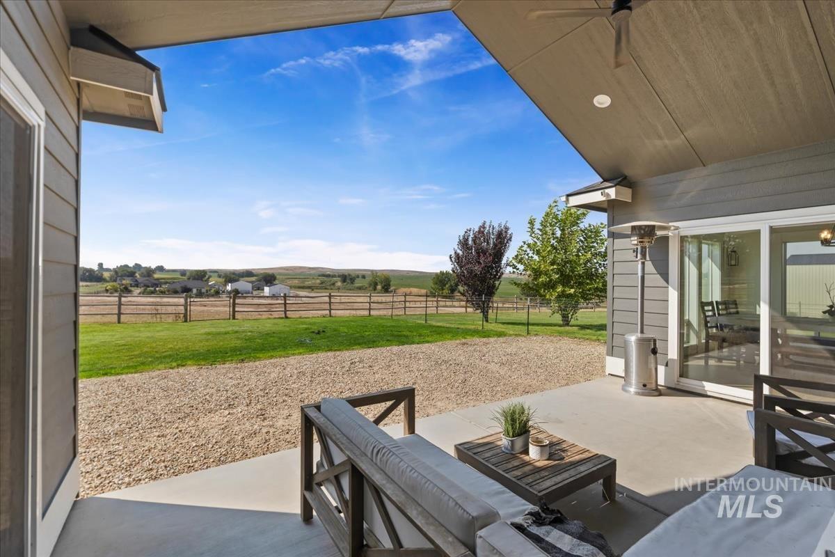 Fenced backyard featuring a patio area and a view of rural / pastoral area