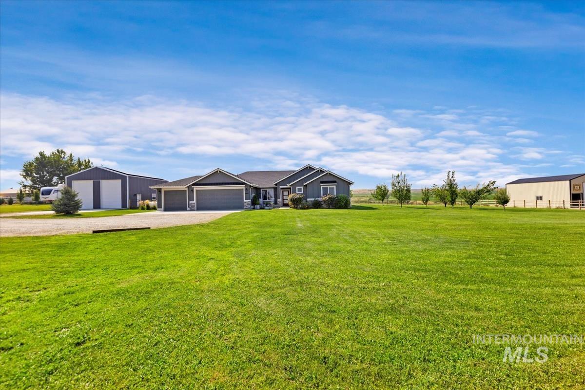 Ranch-style home featuring a front lawn, driveway, and a garage