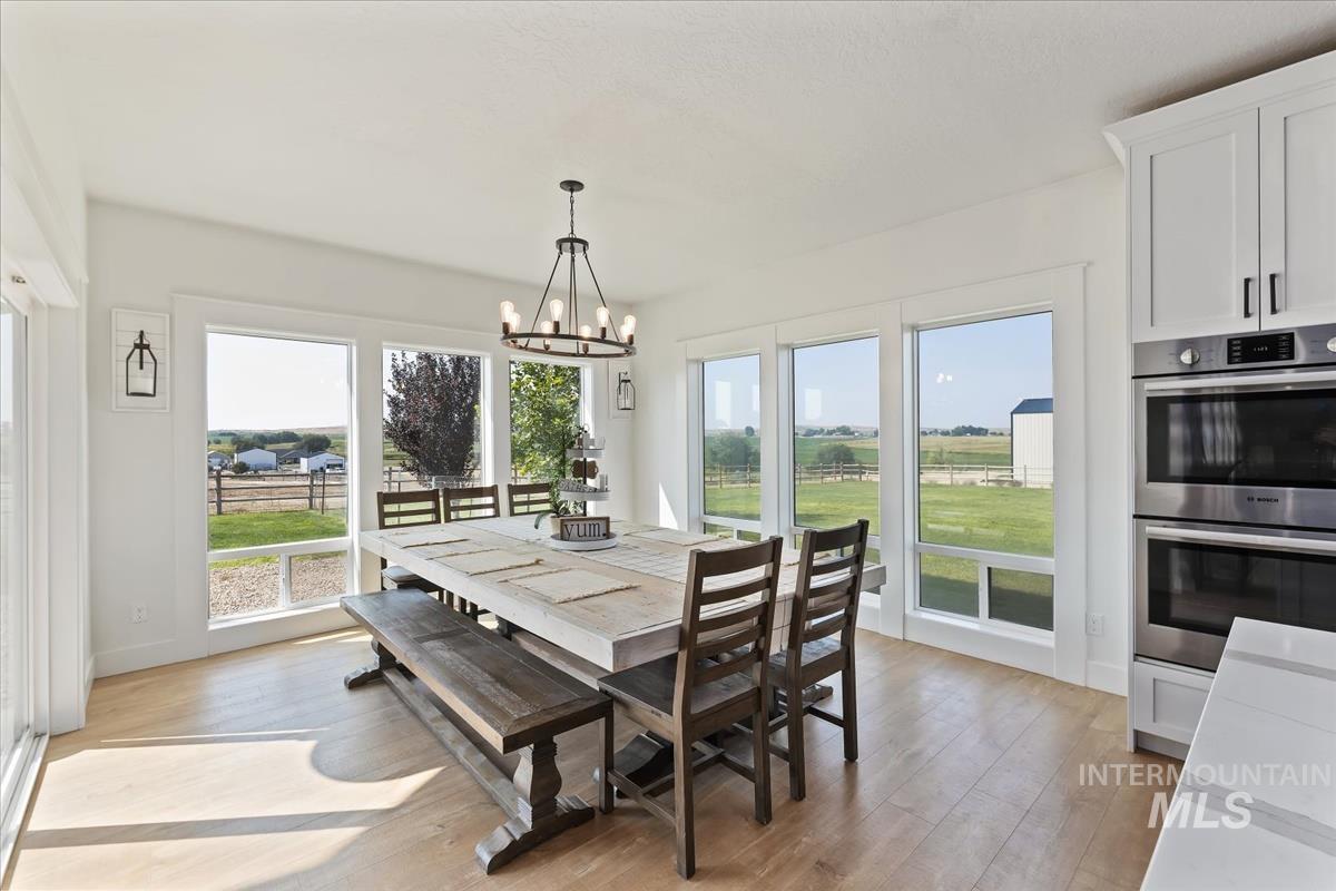 Dining room featuring light wood-type flooring, plenty of natural light, and a chandelier