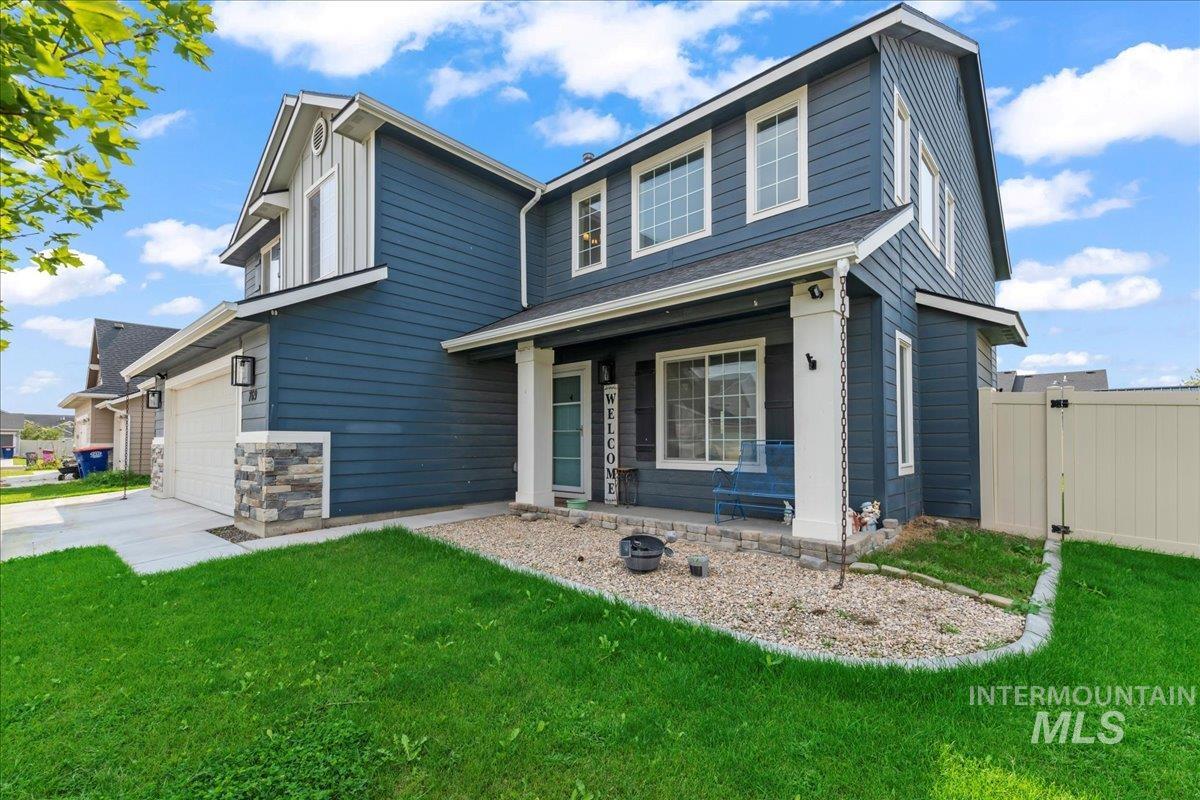 View of front facade with a garage, a porch, driveway, and stone siding