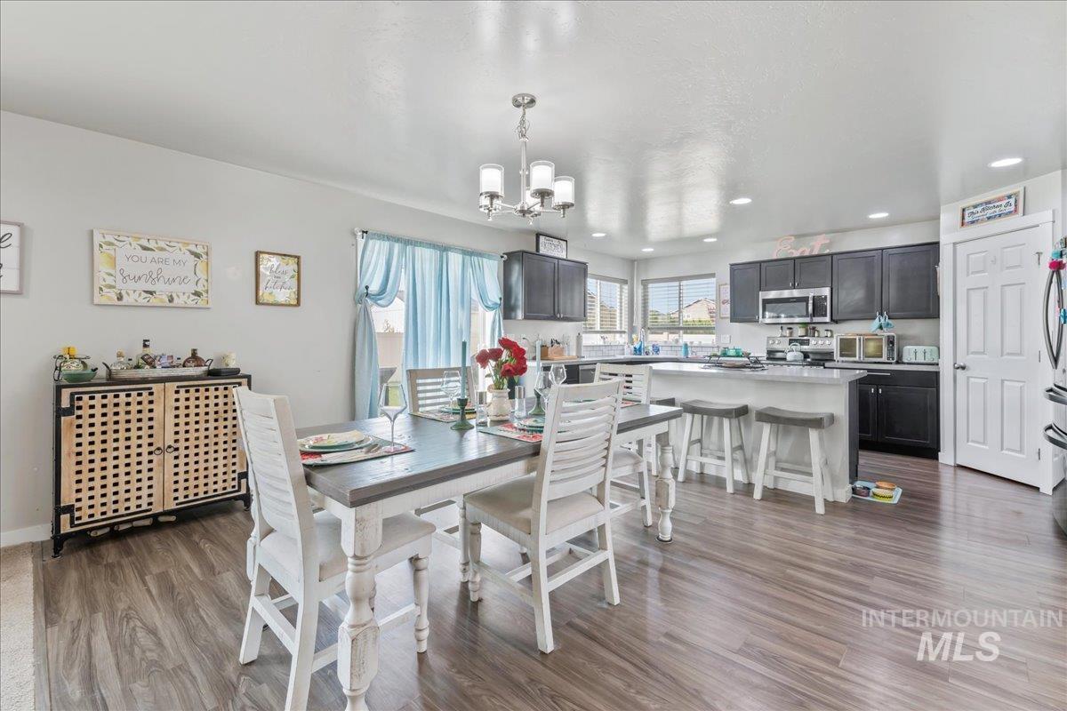 Dining space with light wood-type flooring, a chandelier, and recessed lighting