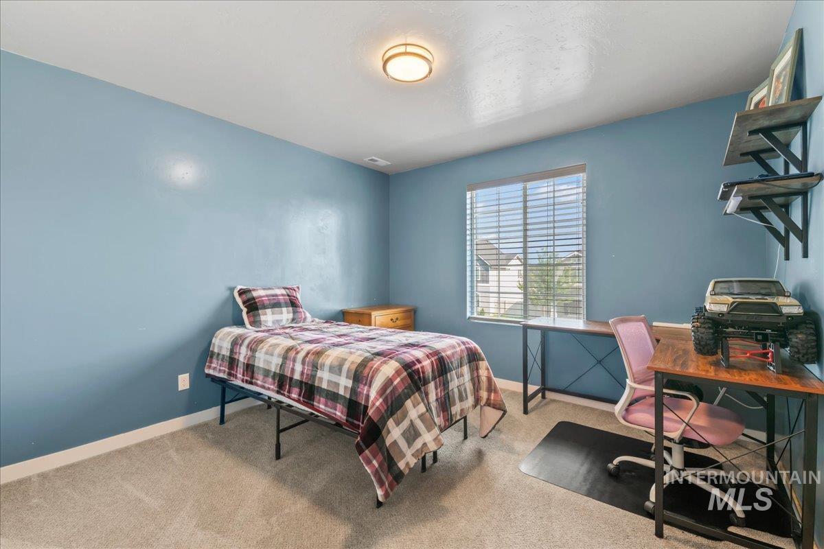 Bedroom featuring carpet flooring and a desk