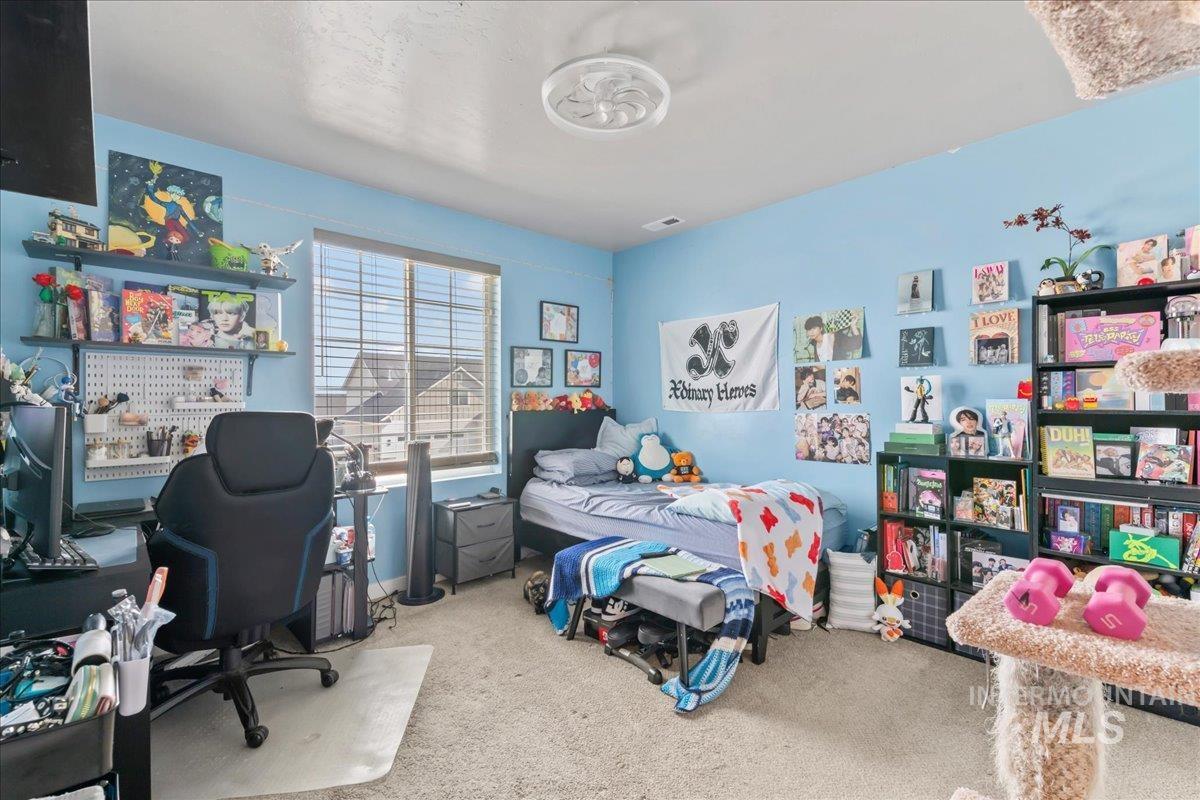 Carpeted bedroom featuring a desk
