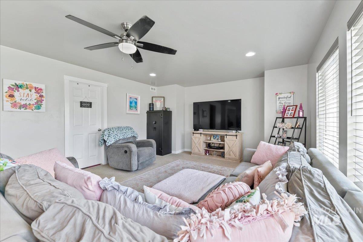 Carpeted living area featuring recessed lighting and a ceiling fan