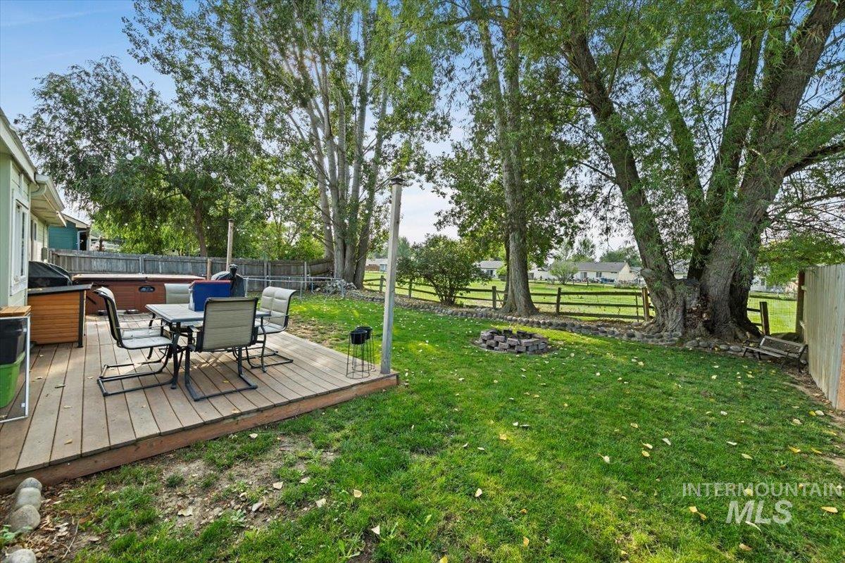 Fenced backyard with a wooden deck and outdoor dining space