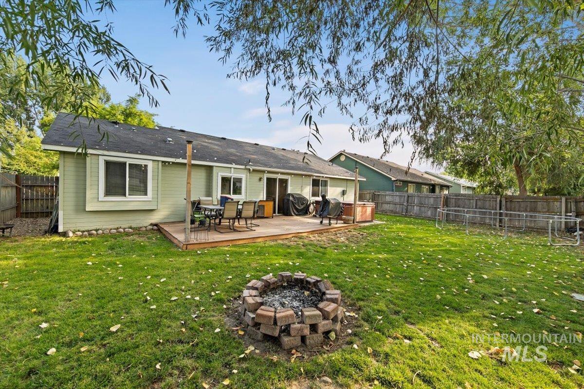 Rear view of house with a fire pit, a fenced backyard, and a deck