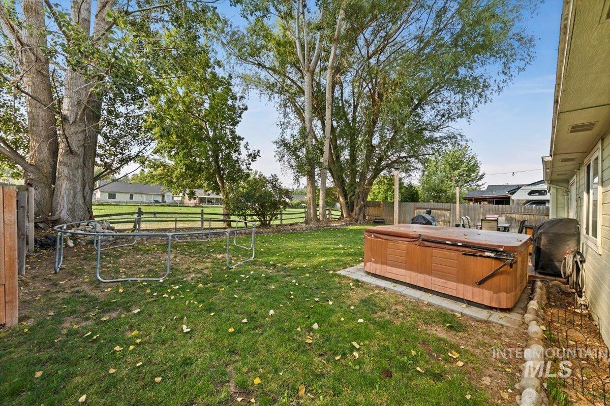 Fenced backyard with a hot tub