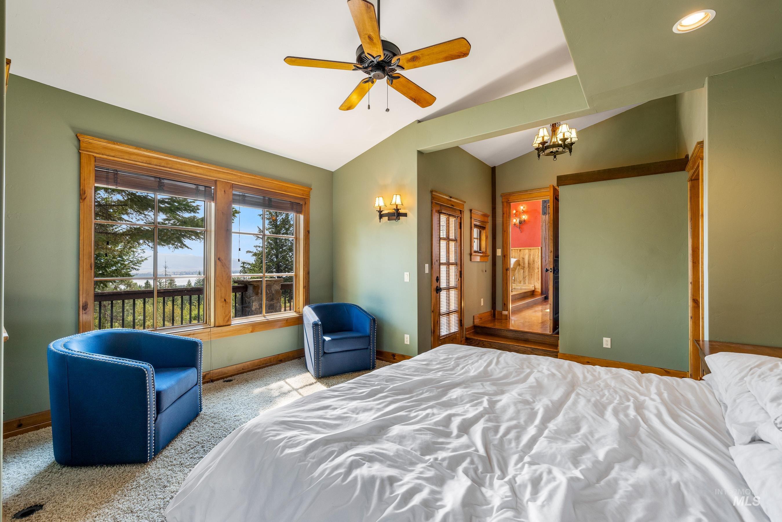 Bedroom with vaulted ceiling, carpet, a chandelier, and ceiling fan