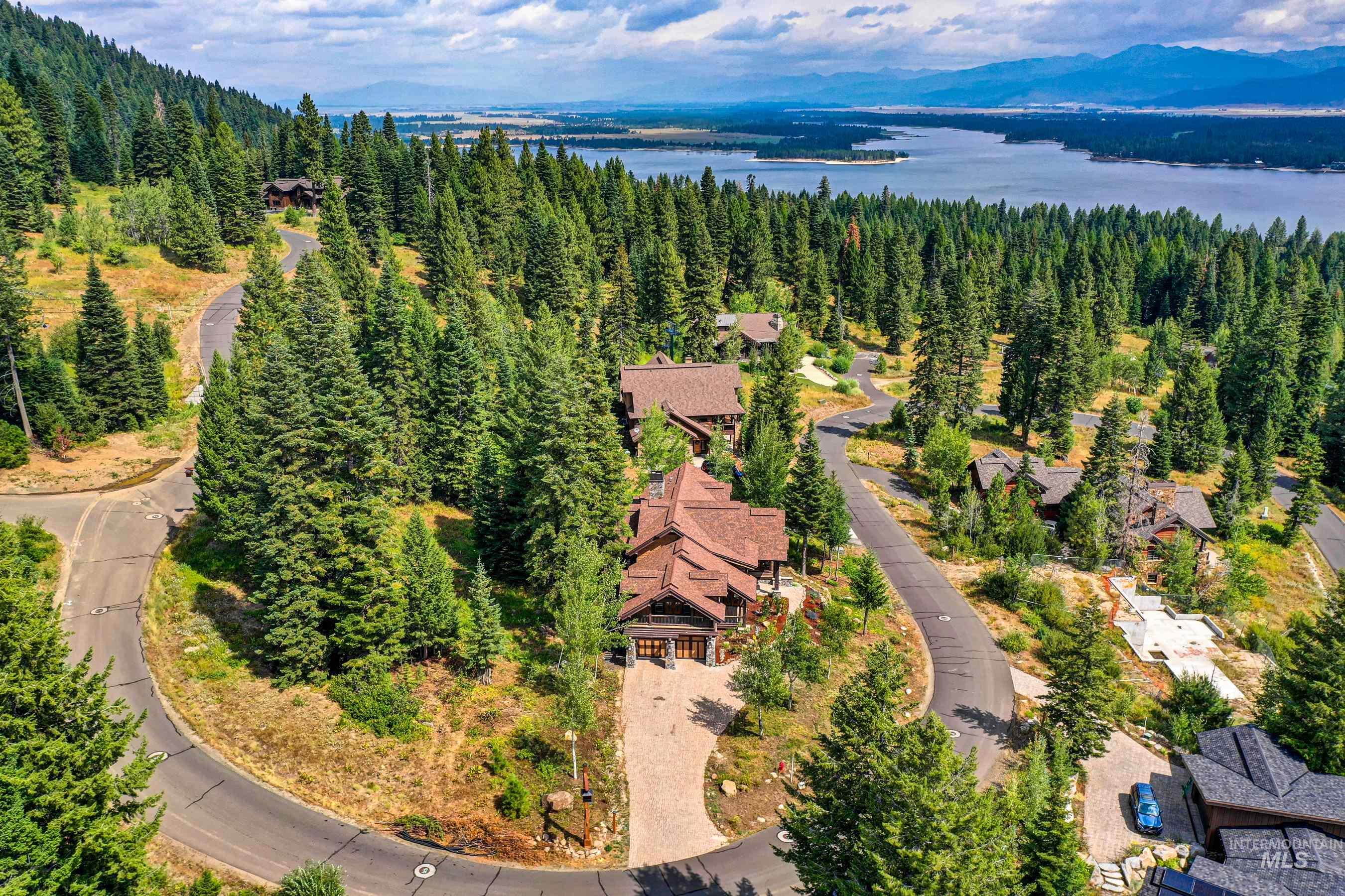 Aerial view of residential area featuring a heavily wooded area and a nearby body of water