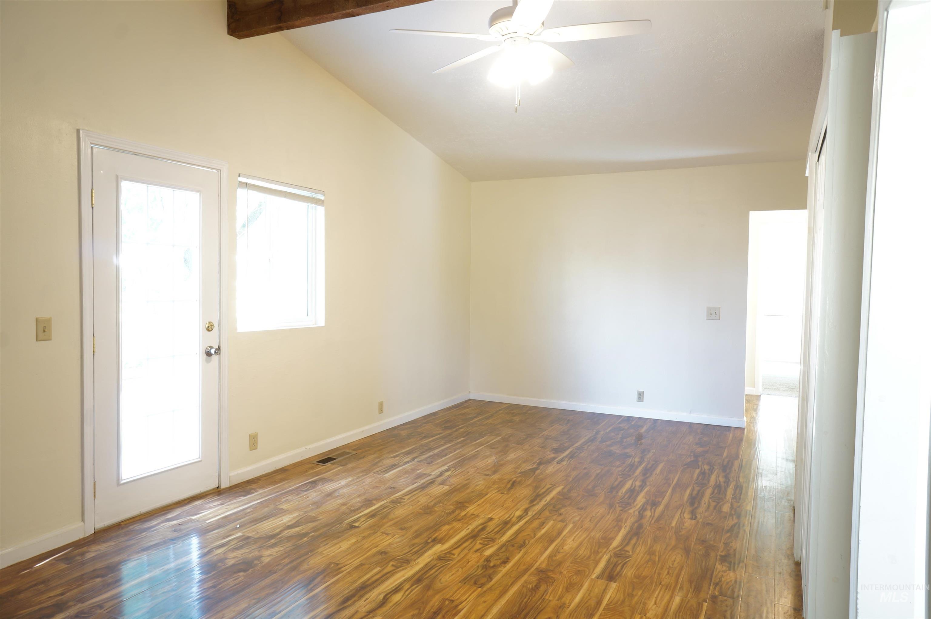 Spare room with dark wood finished floors and a ceiling fan