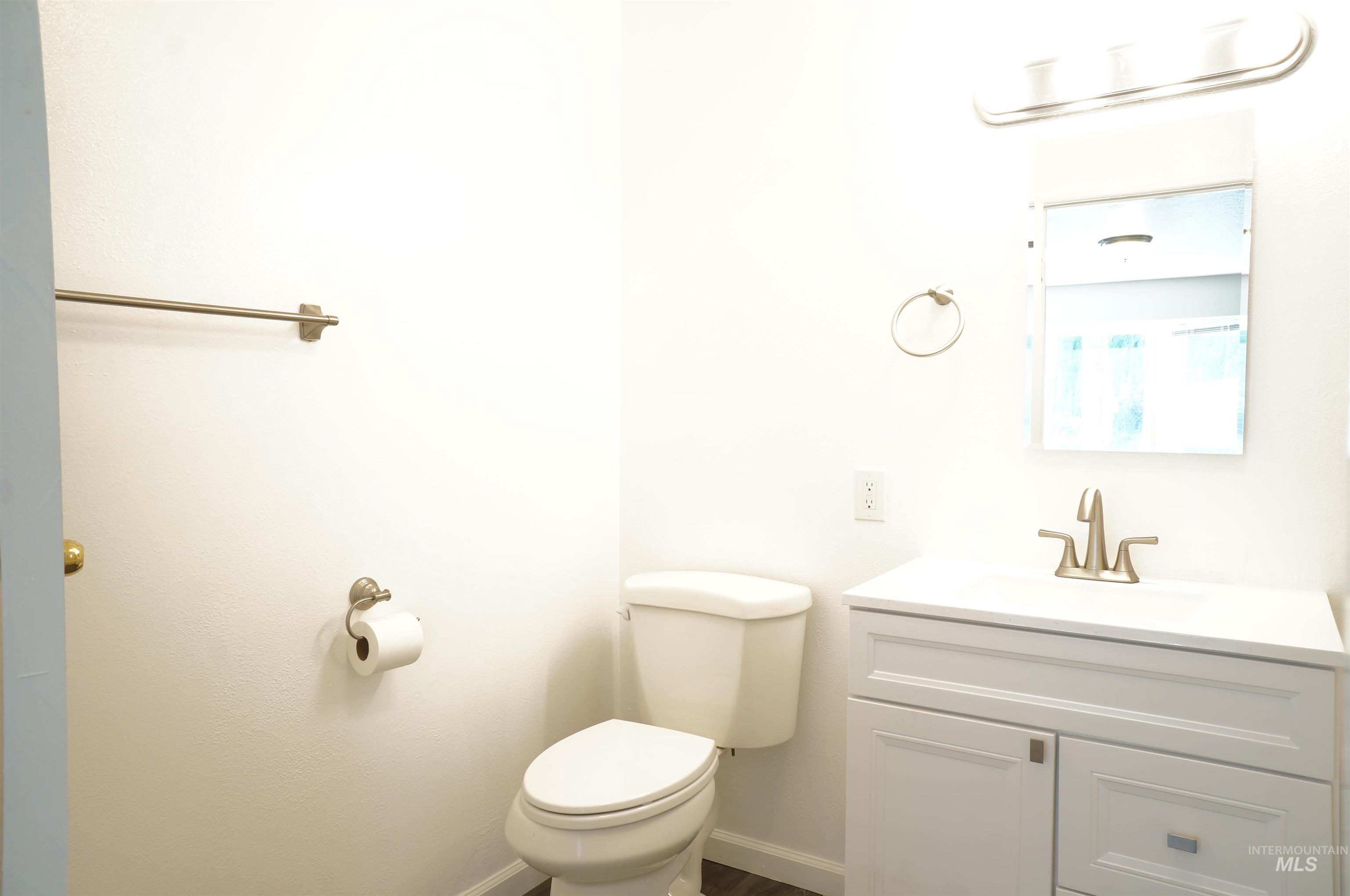 Half bathroom featuring vanity and toilet