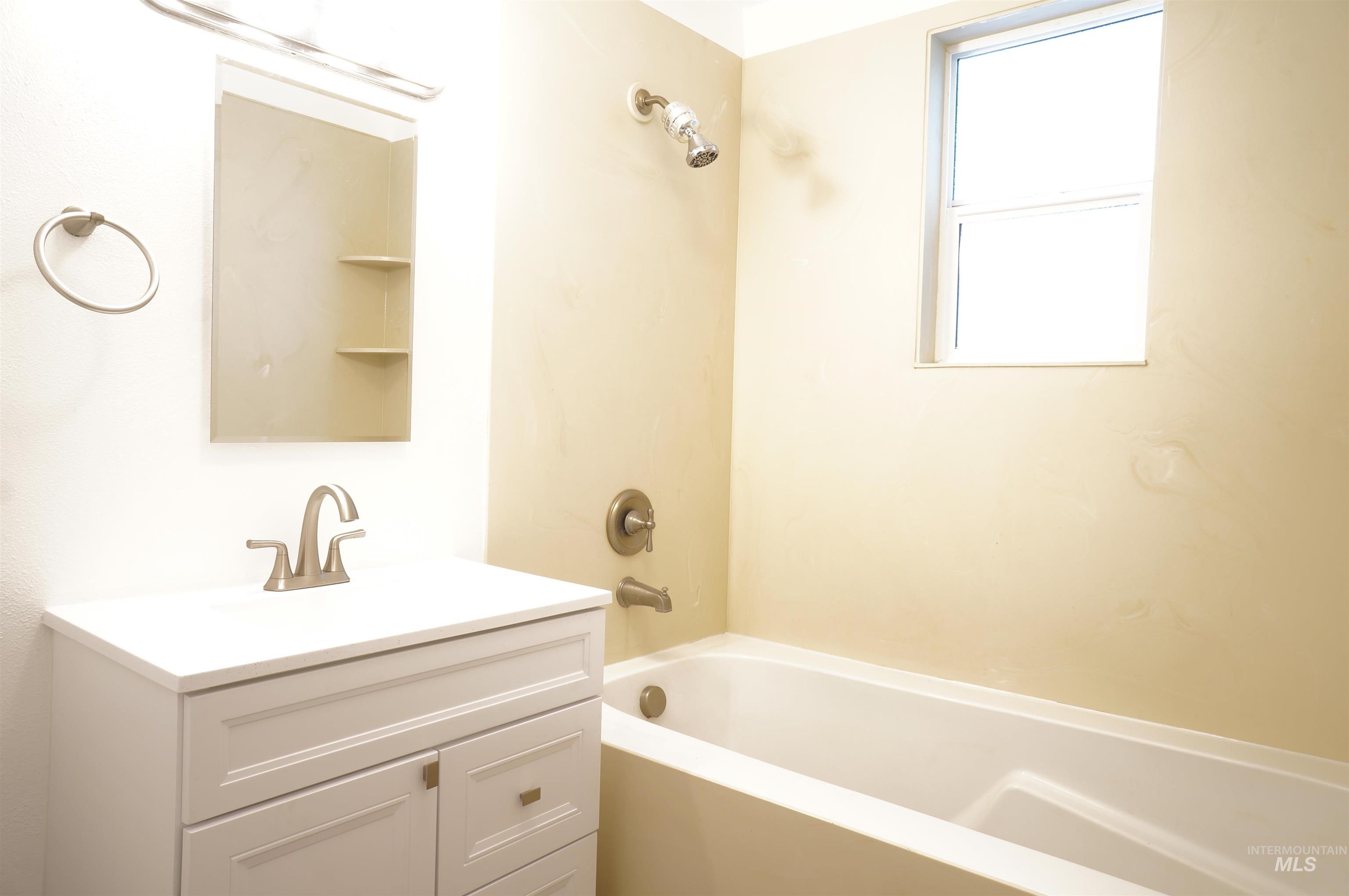 Bathroom with vanity and bathtub / shower combination