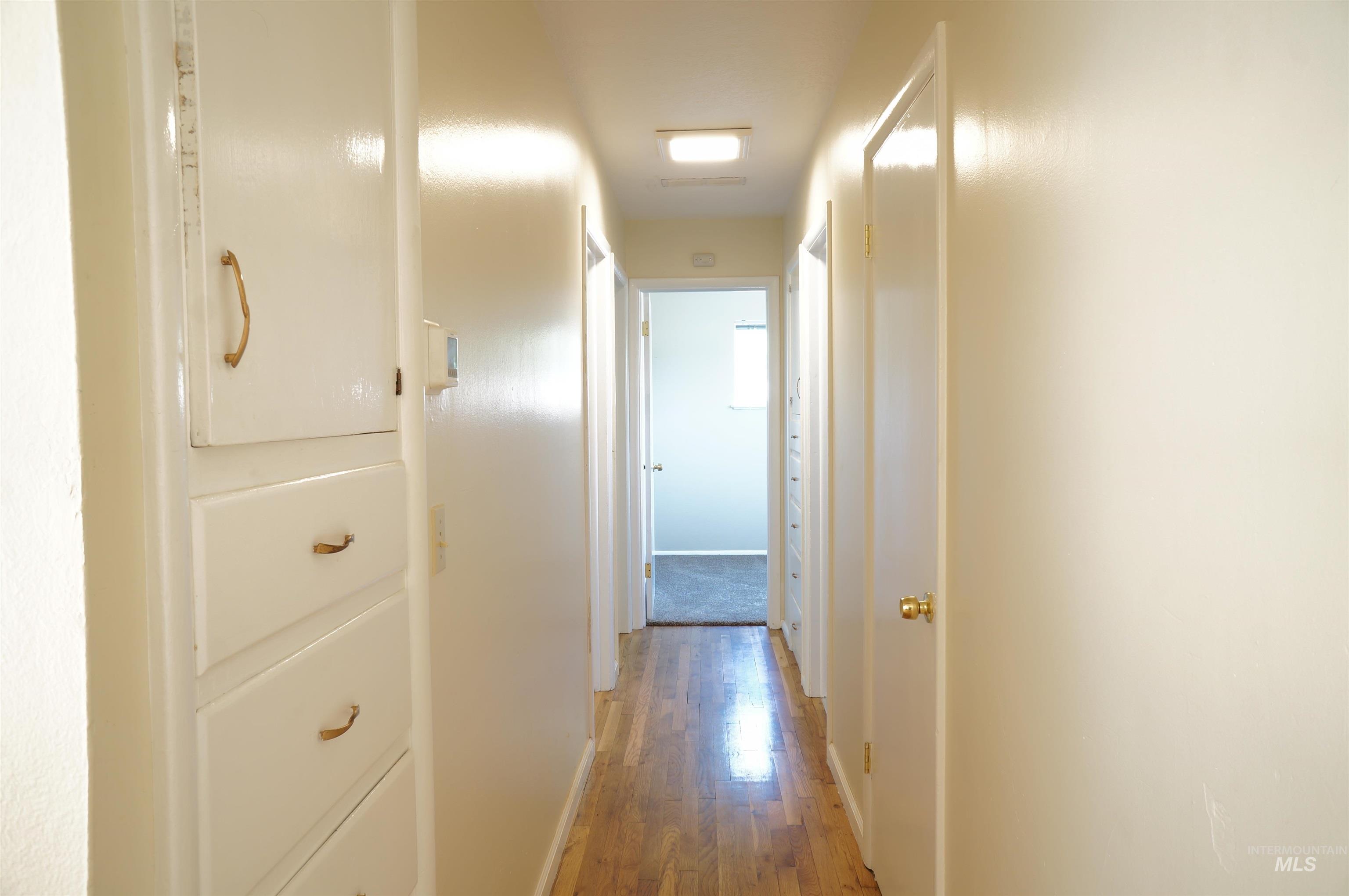 Hall with light wood-style flooring and baseboards