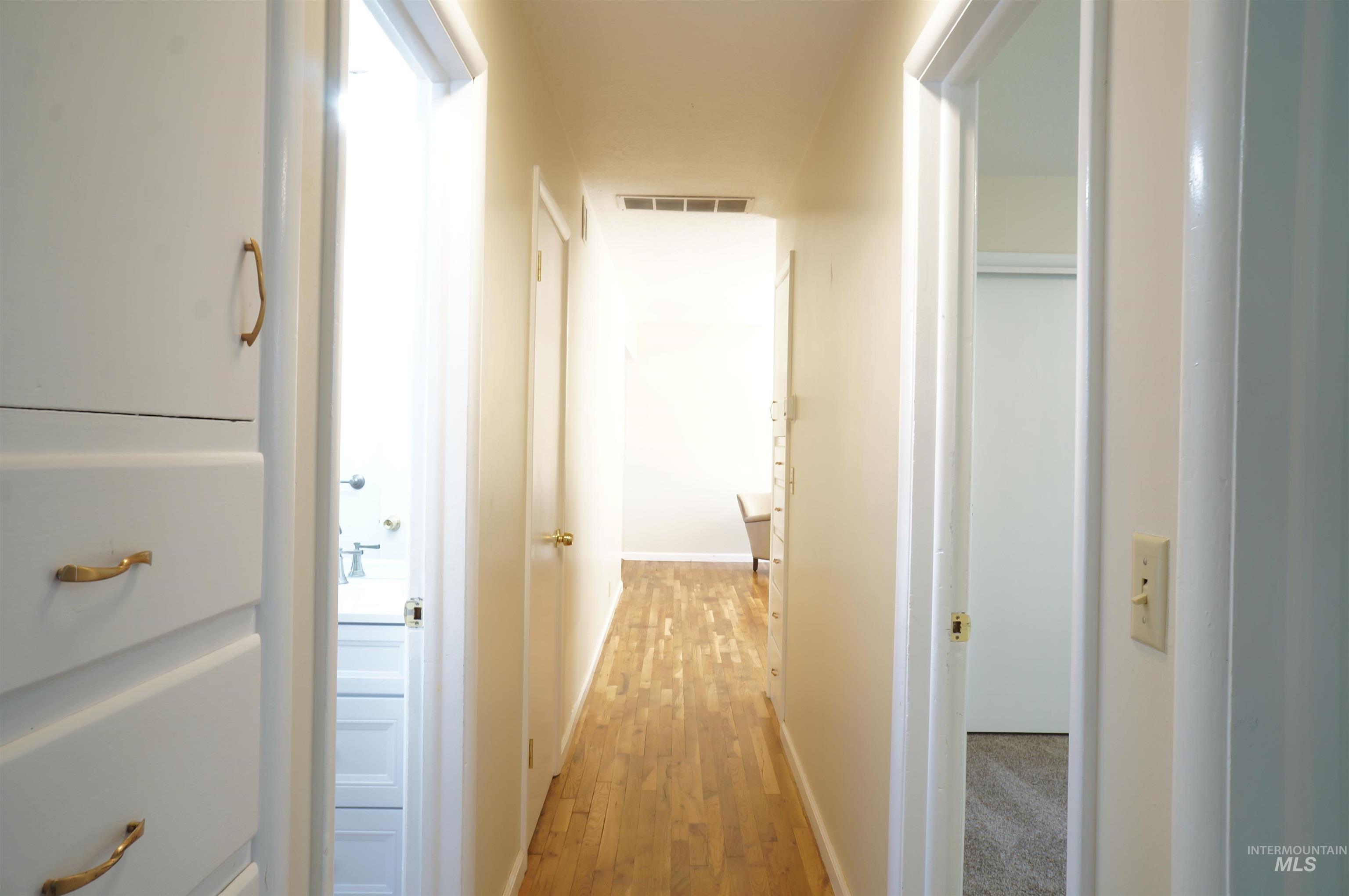 Hallway featuring light wood-style floors and baseboards
