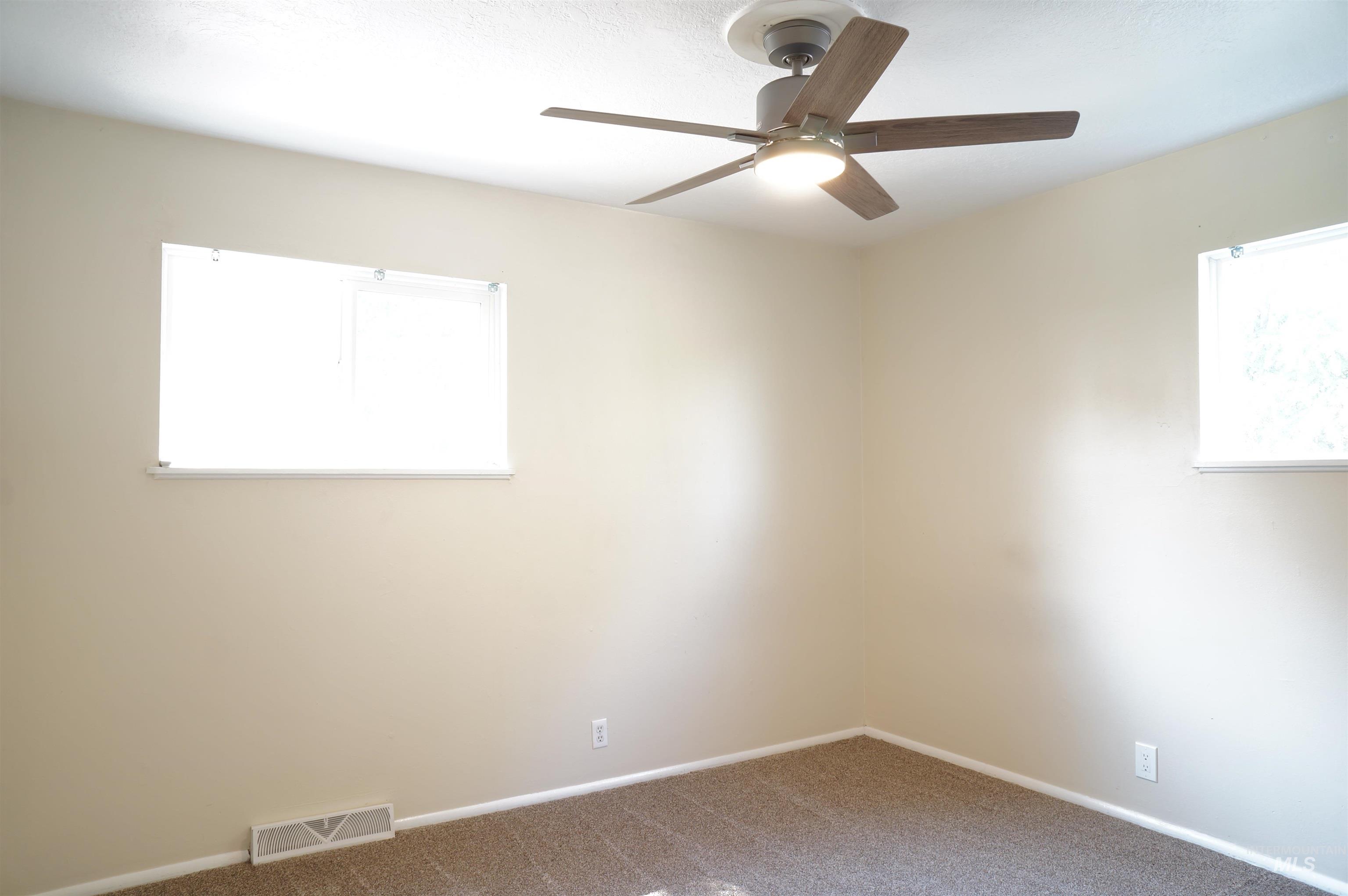 Carpeted empty room with baseboards and ceiling fan