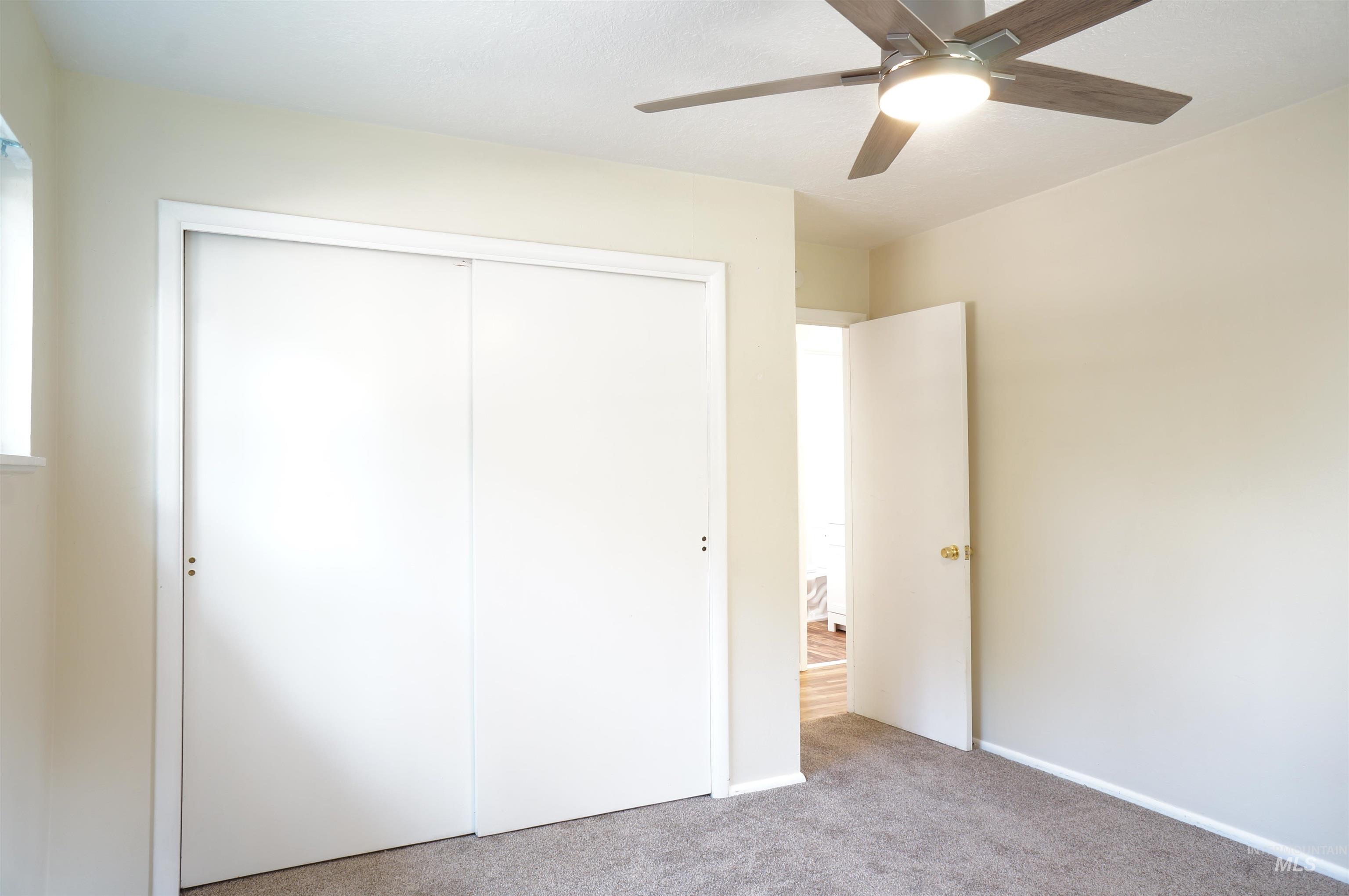 Unfurnished bedroom with carpet flooring, a ceiling fan, and a closet