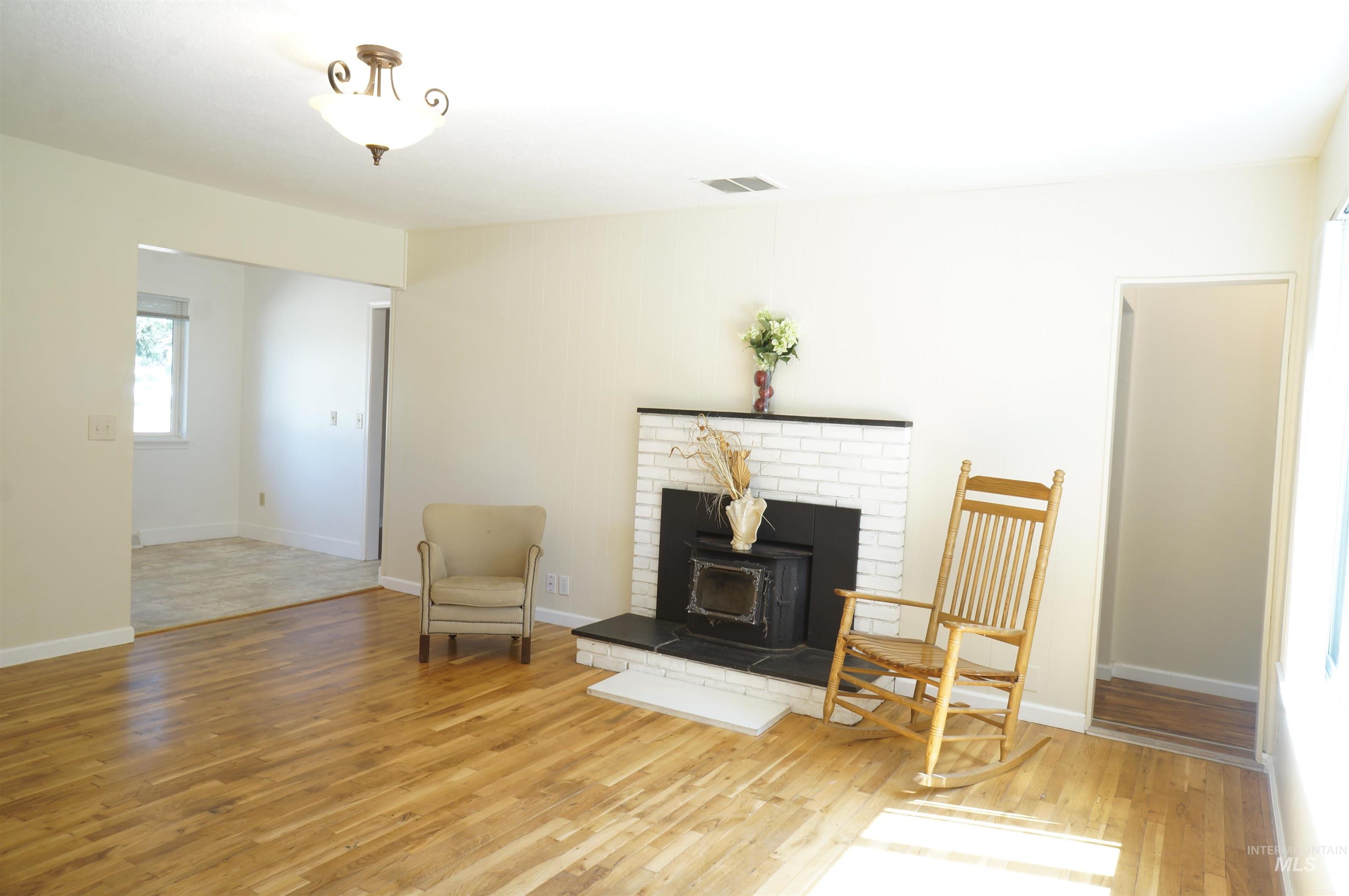 Sitting room with wood finished floors and a wood stove
