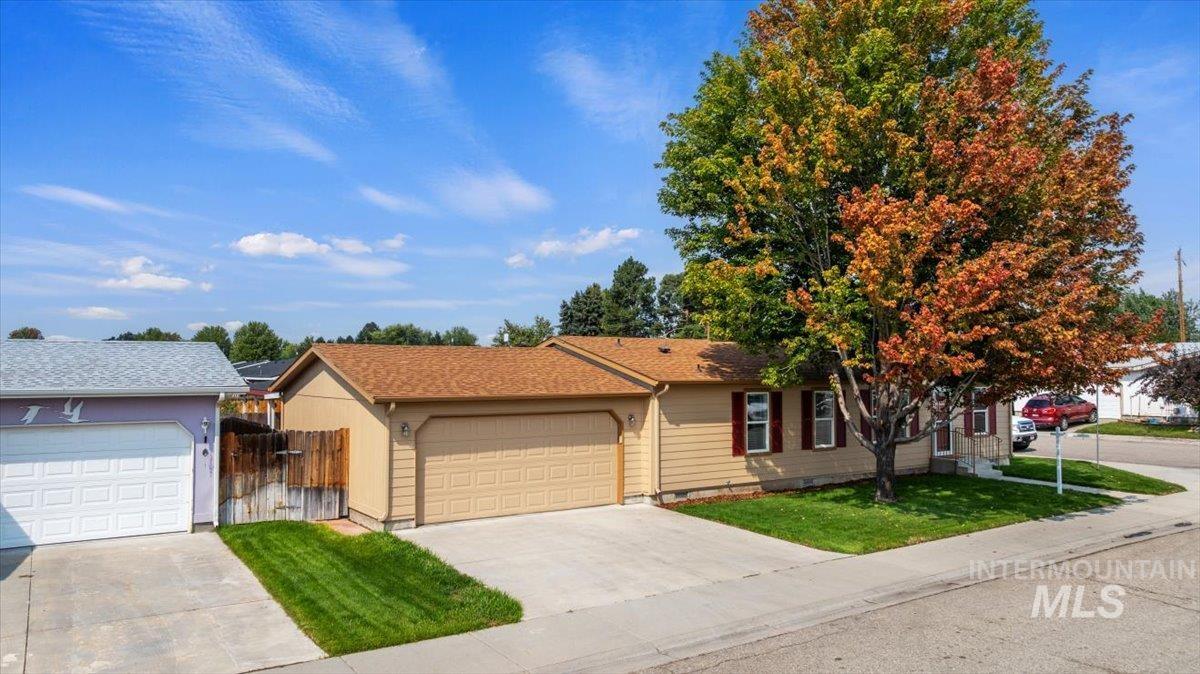 Single story home featuring concrete driveway, a gate, and a garage