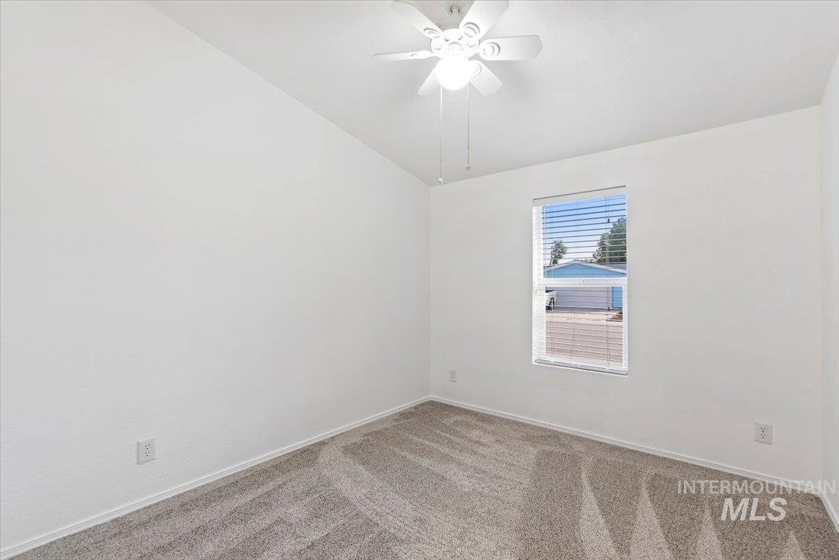 Unfurnished room with carpet flooring, ceiling fan, and lofted ceiling